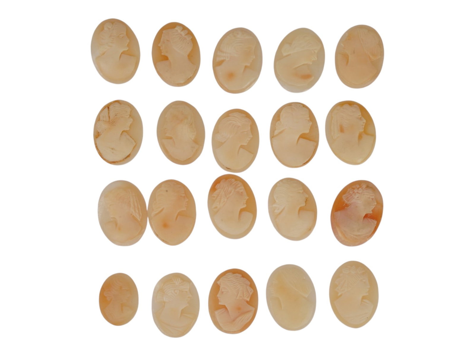 LOT OF FEMALE PORTRAIT CARVED SHELL CAMEOS: A lot of 20 hand carved conch shell cameos. Each piece depicts a female profile portrait rendered in high relief. Oval shape. Collectible Jewelry And Glyptic Art, Sculpture. THIS LOT IS ELIGIBLE FOR A