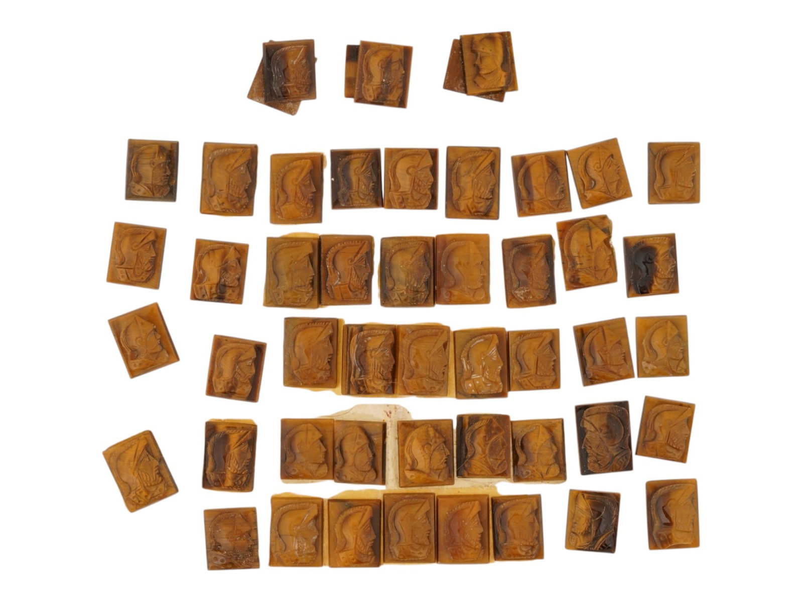 COLLECTION OF PORTRAIT CARVED TIGERS EYE CAMEOS: A collection of hand carved tigers eye cameos. A total of 47 items. Each piece features a knight profile portrait rendered in high relief. Rectangular shape. Collectible Jewelry And Glyptic Art, Sculp