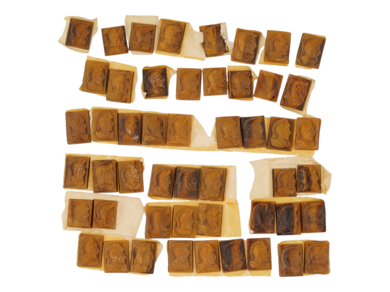 COLLECTION OF PORTRAIT CARVED TIGERS EYE CAMEOS: A collection of hand carved tigers eye cameos. A total of 50 items. Each piece features a knight profile portrait rendered in high relief. Rectangular shape. Collectible Jewelry And Glyptic Art, Sculp
