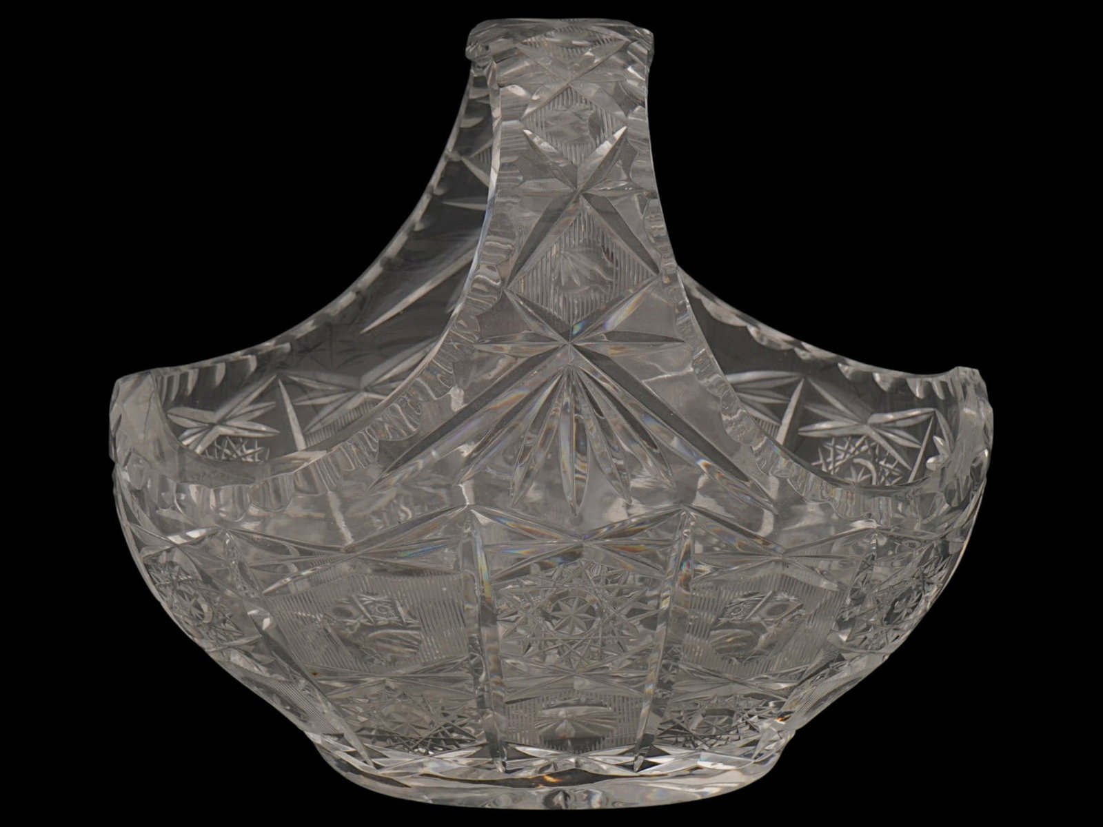 VINTAGE BOHEMIAN LEAD CUT CRYSTAL CENTERPIECE BASKET: A vintage Bohemian lead cut crystal basket designed as a decorative centerpiece. The high-sided scalloped body is adorned with pinwheel, crisscross, and fan-cut patterns, with the seamlessly integrate