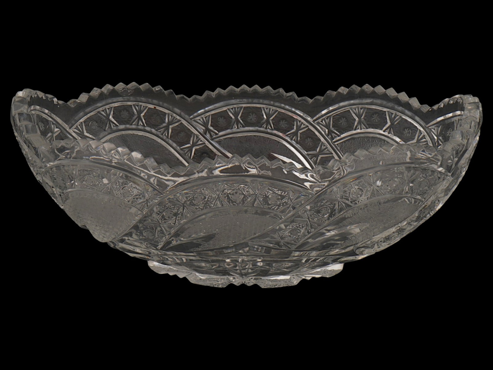 VINTAGE CLEAR LEAD CRYSTAL FRUIT BOWL LATE 20TH C: A vintage clear lead crystal fruit bowl. Circa the late 20th century. Footed oval piece with jagged figurative rim. Carved hobstar and crosshatching patterns. Unmarked. Presumably of Russian origin. C