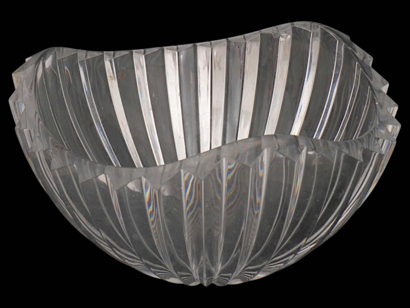 VINTAGE FLUTED CLEAR CRYSTAL BOWL WITH SCALLOPED RIM: An elegant clear crystal bowl features deep vertical fluting extending from the base to a serrated, scalloped rim. The piece is constructed from heavy lead crystal, providing a high degree of transpar