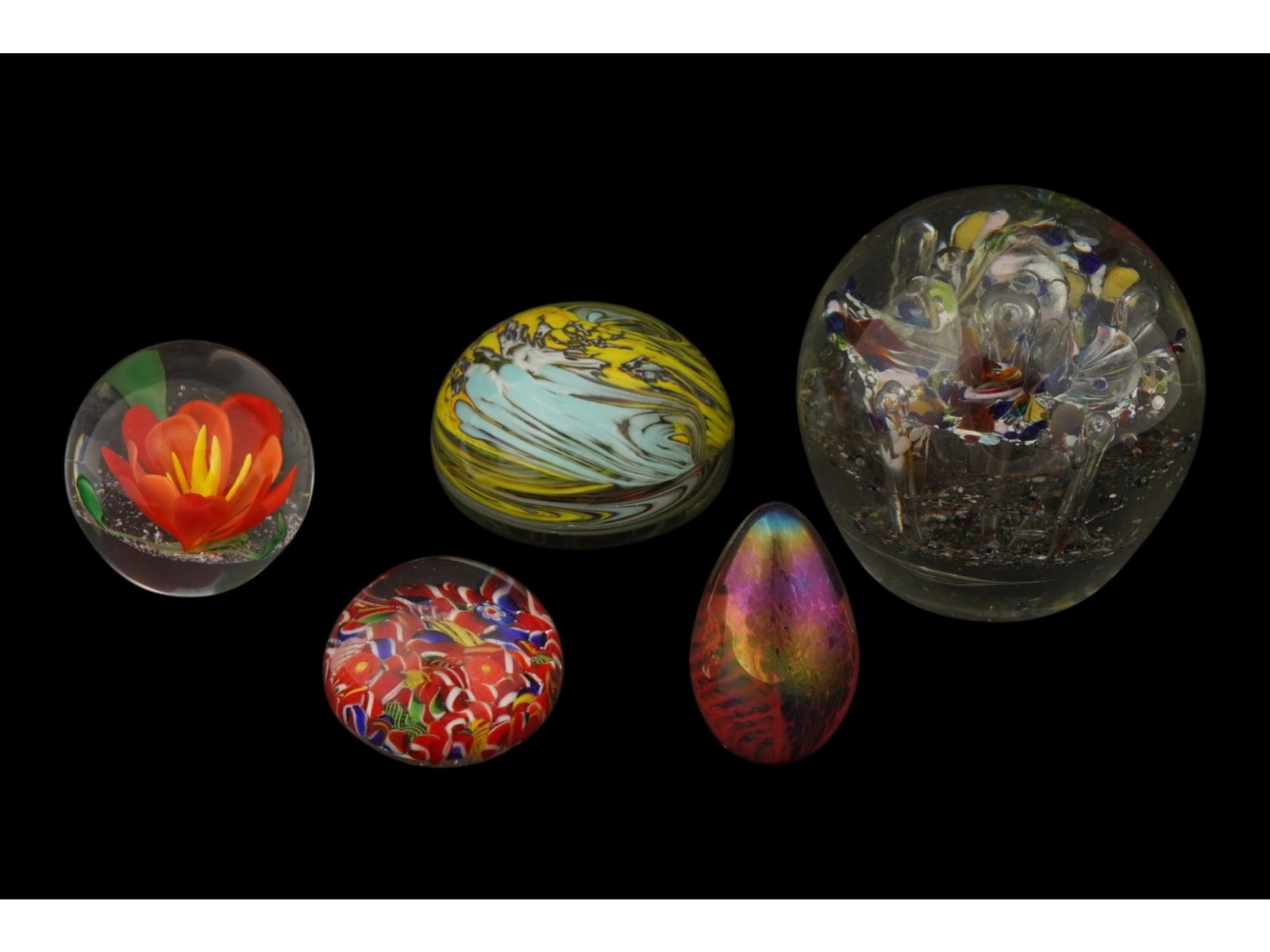 COLLECTION OF VINTAGE HAND BLOWN ART GLASS PAPERWEIGHTS: A collection of five vintage hand-blown art glass paperweights showcasing a variety of traditional glassmaking techniques. The group includes examples with millefiori fragments, controlled bubbles, fl