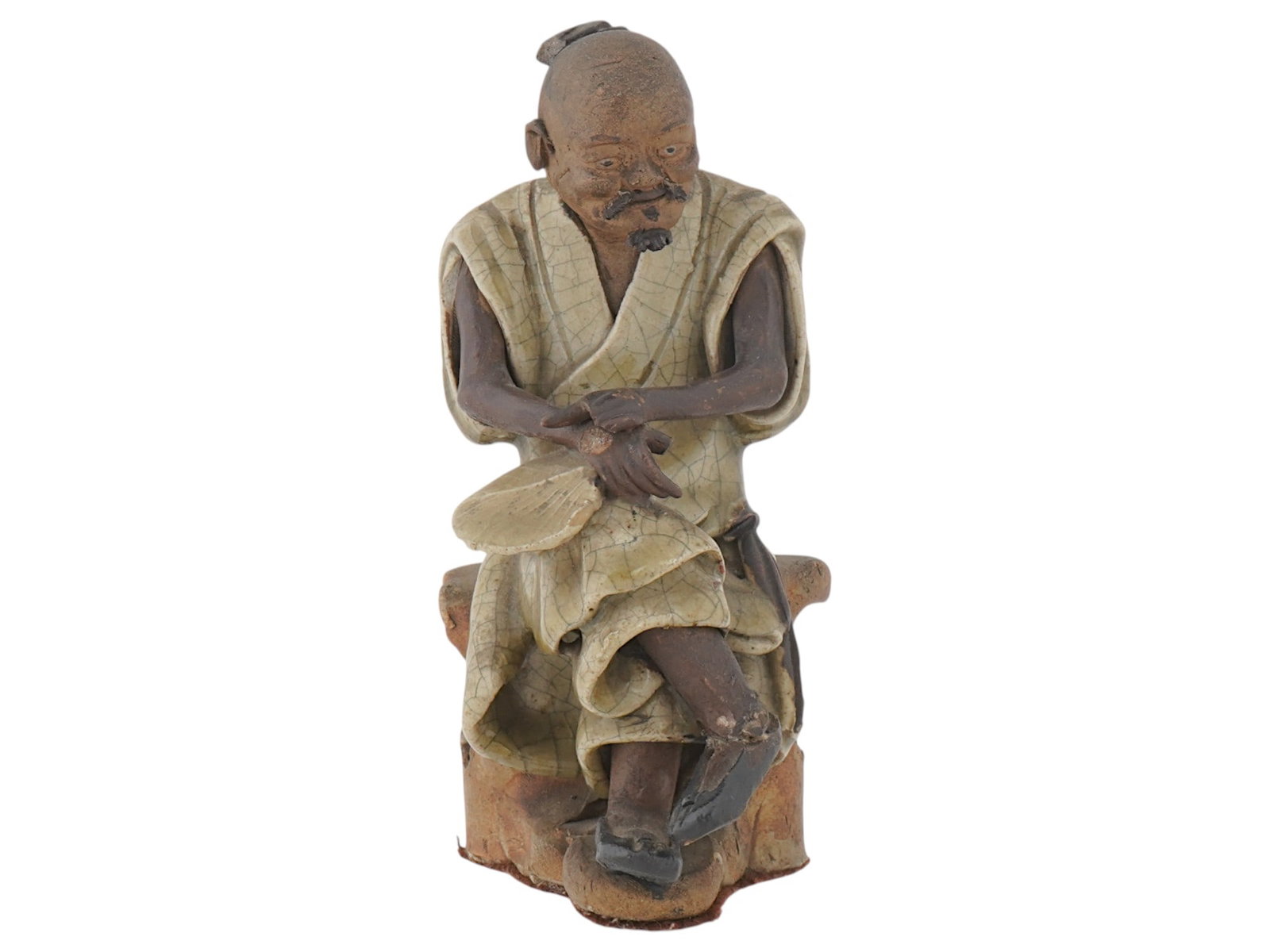 ASIAN CERAMIC FIGURINE OF ELDERLY MAN: An Asian ceramic figurine of an elderly man. The figurine is seated, with his arms crossed. He is wearing a robe that appears to be crackle glazed. He has a thin mustache and a small topknot of hair. 