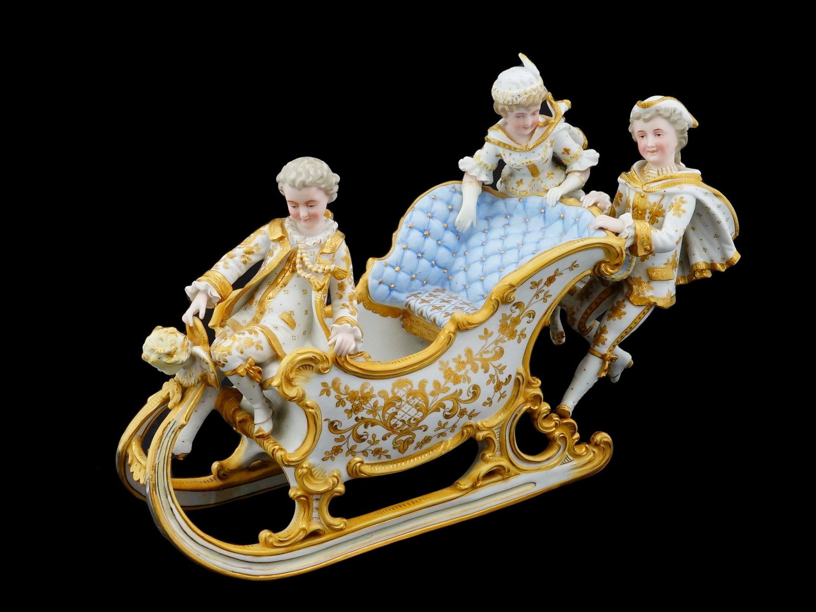 FRENCH BISQUE PORCELAIN WINTER FIGURAL GROUP MARKED: A large French bisque porcelain figural group, dating to circa 1900. The ware depicts a winter scene with three figures in 18th century costume navigating an ornate Rococo style sleigh. The sleigh is 
