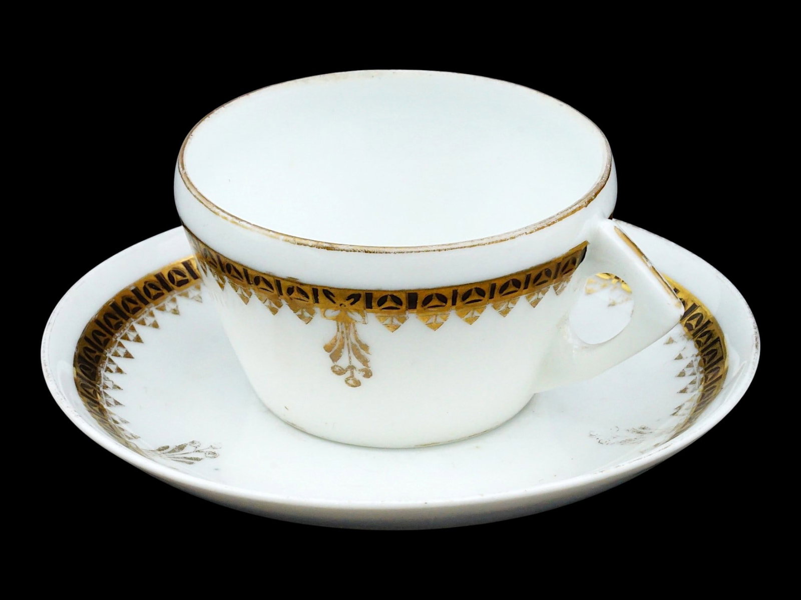 GARDNER IMPERIAL RUSSIAN PORCELAIN CUP AND SAUCER: An Imperial Russian porcelain tea pair. White pieces decorated with a cobalt blue band with gilded pattern. Marked with a red overglaze hallmark on the bottom. Gardner was the first Russian private po