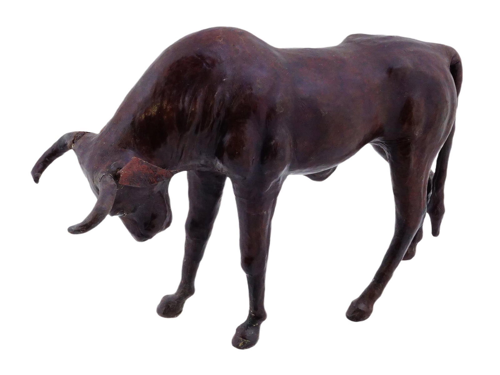 LARGE VINTAGE GENUINE LEATHER BULL FIGURINE: A large vintage figurine made of genuine leather, modeled in the shape of a bull. The bull is depicted standing with its head bowed and its horns pointed forward. Circa mid to late 20th century. Antiq