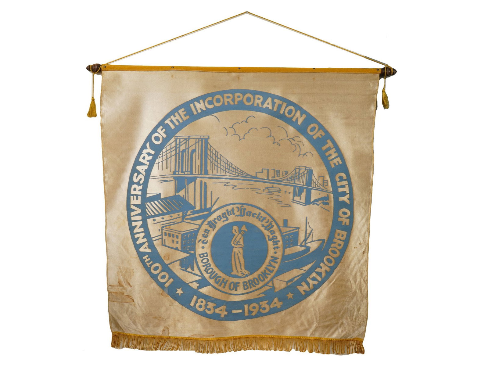 AMERICAN 100TH ANNIVERSARY COMMEMORATIVE FABRIC BANNER: A commemorative fabric banner celebrates the 100th anniversary of the Borough of Brooklyn, spanning the years 1854 to 1954. The central design features a circular emblem depicting the Brooklyn Bridge 