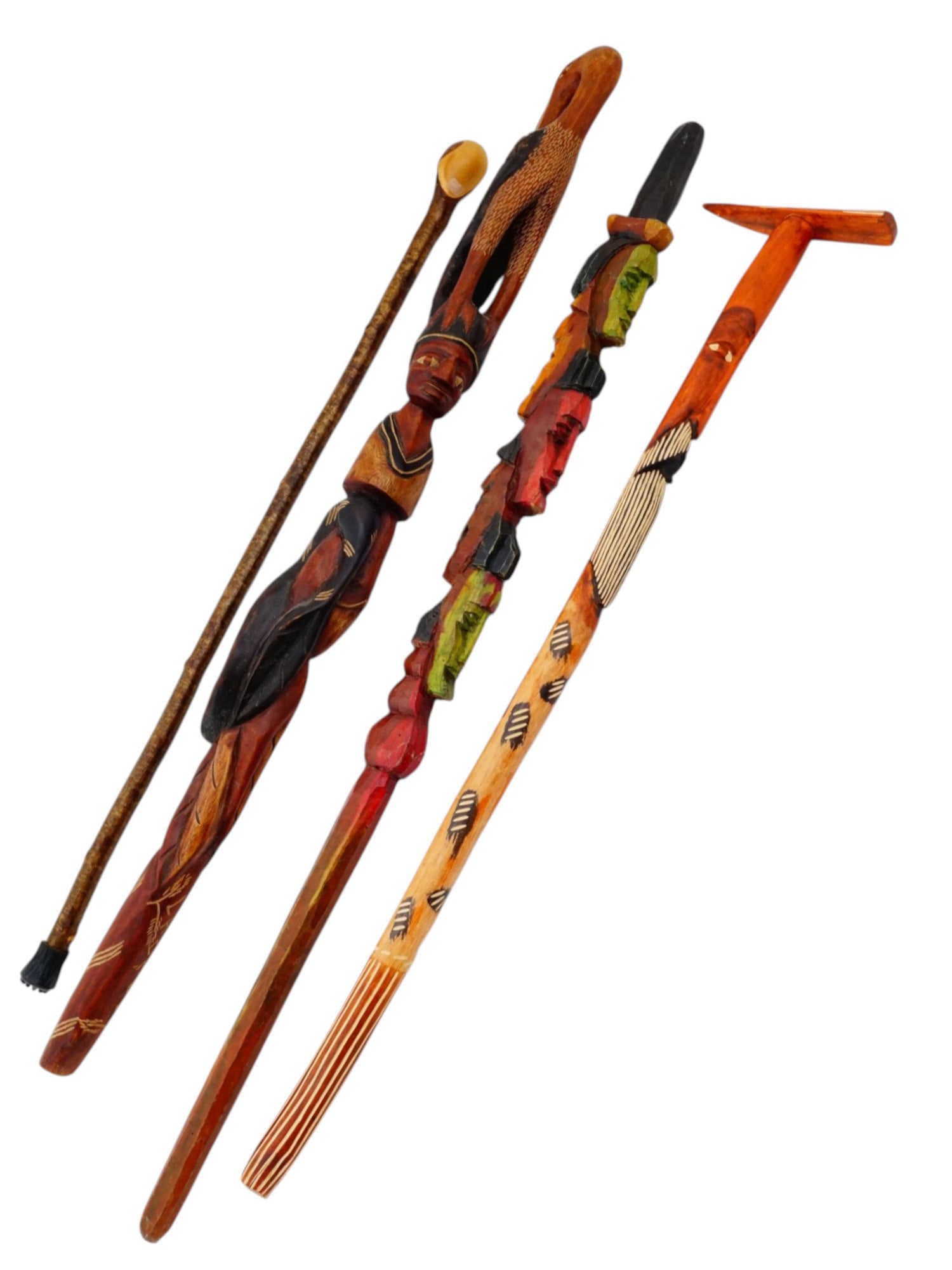 AFRICAN AND HAITIAN WOODEN WALKING CANES: A group of four African and Haitian figurative wooden walking canes. The canes feature a variety of intricate designs featuring human heads and birds. Some are marked Haiti and Labadee. Collectible Wa
