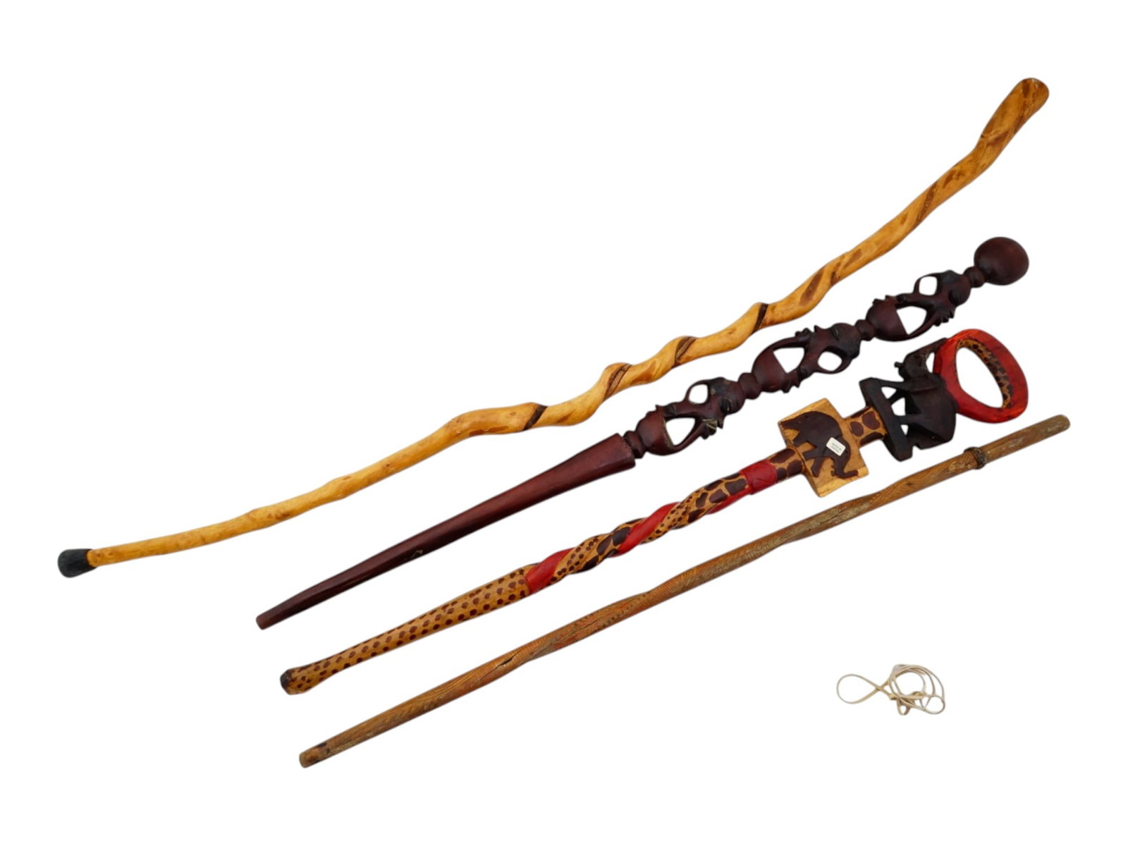 FOUR AFRICAN FIGURATIVE WOODEN WALKING CANES: A group of four African figurative wooden walking canes. The canes feature a variety of intricate designs featuring human heads and elephant motifs. Some are marked Made in Kenya. Collectible Walking 