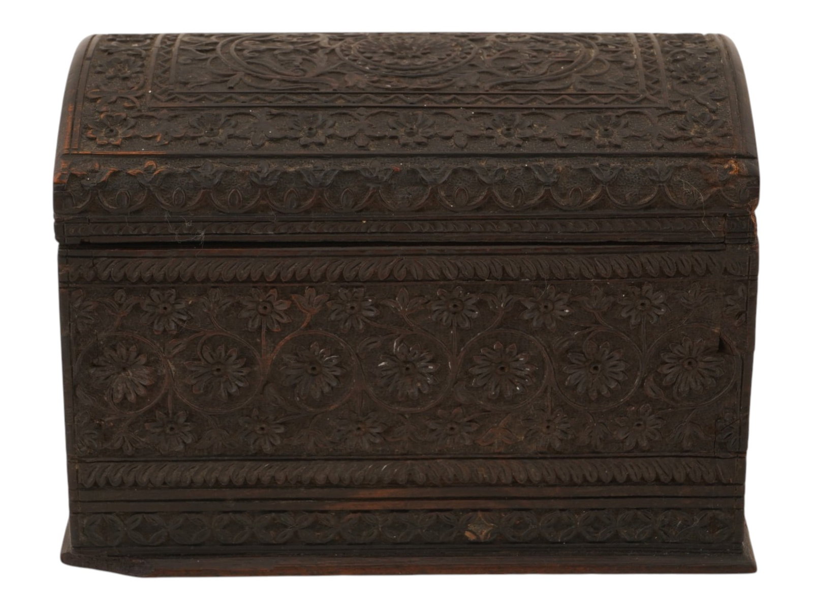 ANTIQUE ANGLO INDIAN CARVED WOOD CASKET BOX: An antique carved wood casket box made in a traditional Anglo-Indian style. The rectangular box features a domed design lid and is richly decorated with hand-carved floral and foliate relief motifs ac