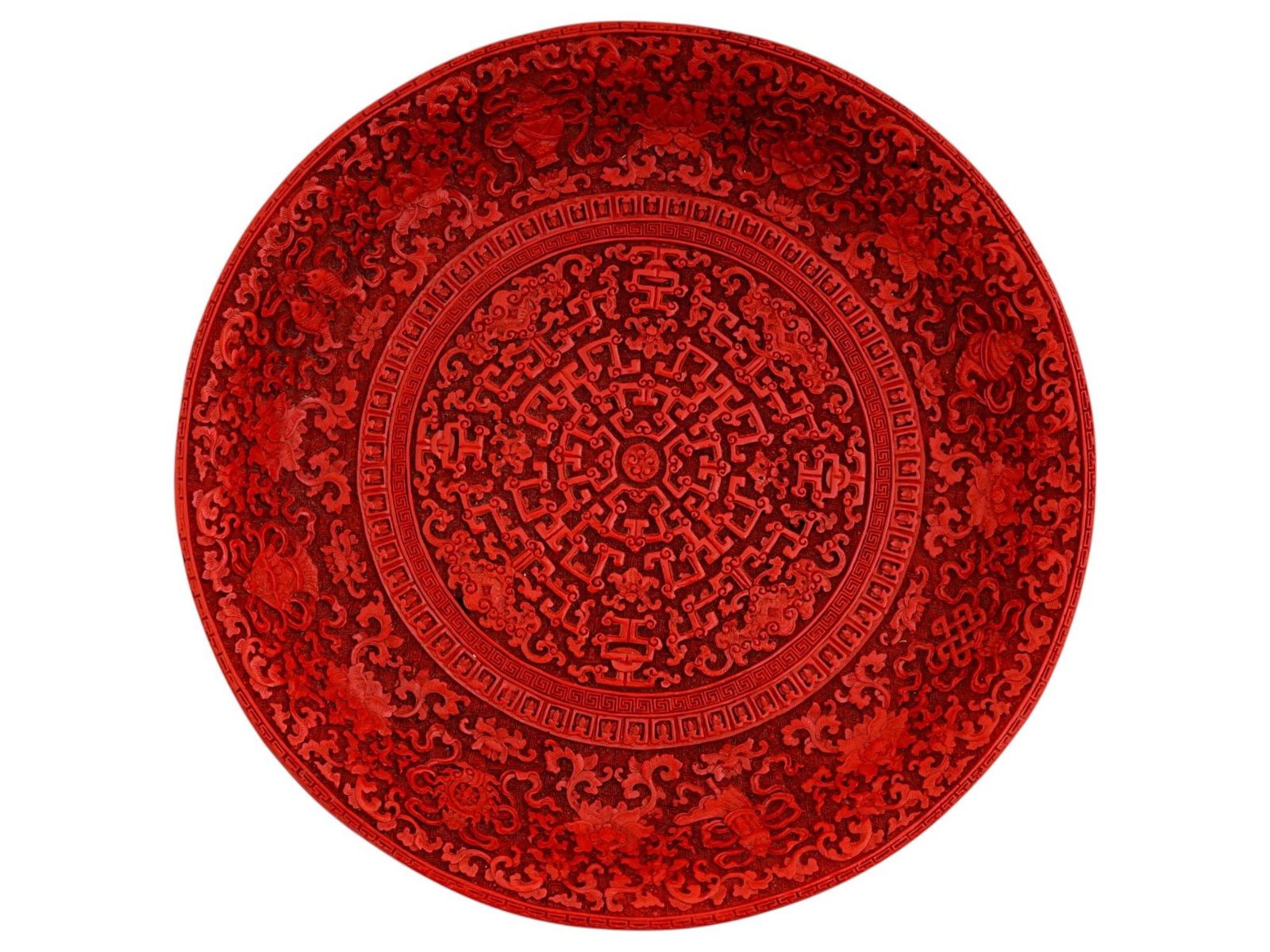 CHINESE CARVED CINNABAR LACQUER SHOU CHARGER: A large and impressive antique Chinese carved red cinnabar lacquer charger or shallow dish. The highly detailed interior is centered by a stylized Shou character (symbolizing longevity), surrounded by