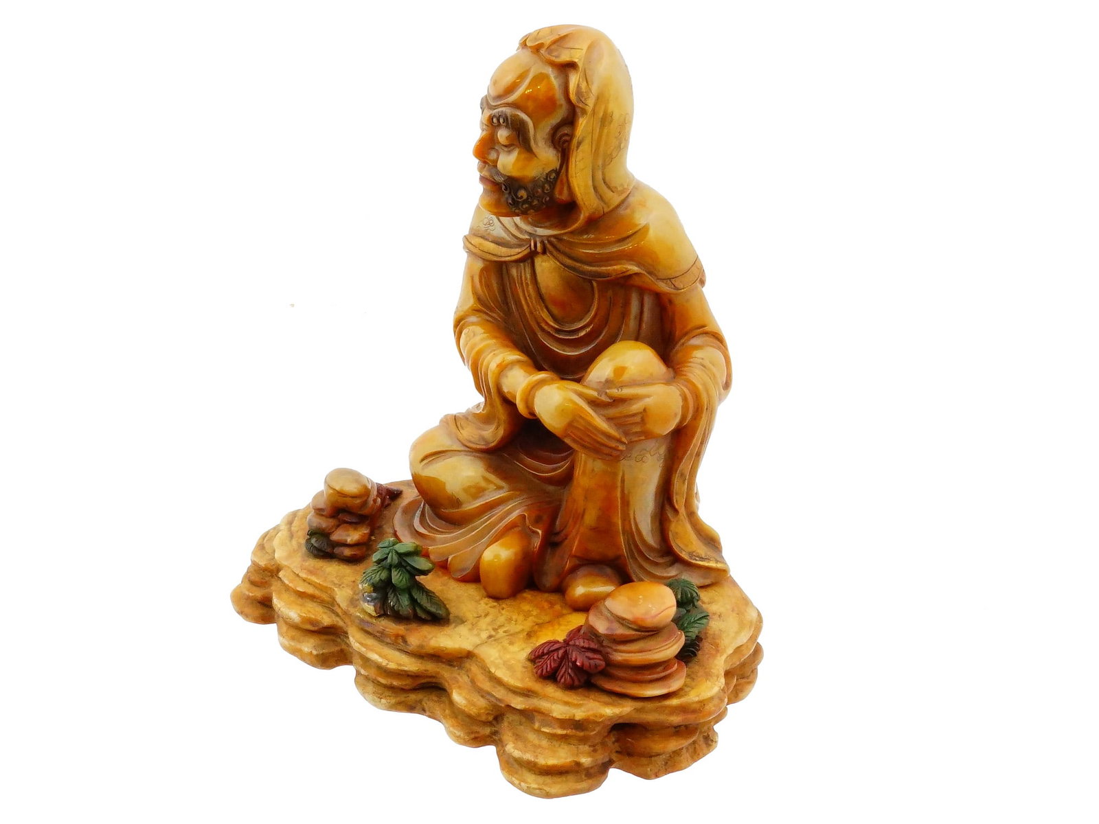 ANTIQUE CHINESE CARVED SOAPSTONE FIGURE OF BODHIDHARMA: An antique Chinese hand-carved soapstone figure of Bodhidharma, accompanied by a separate tiered rockwork display stand. The stone is carved with expressive facial features, flowing robes, and natural