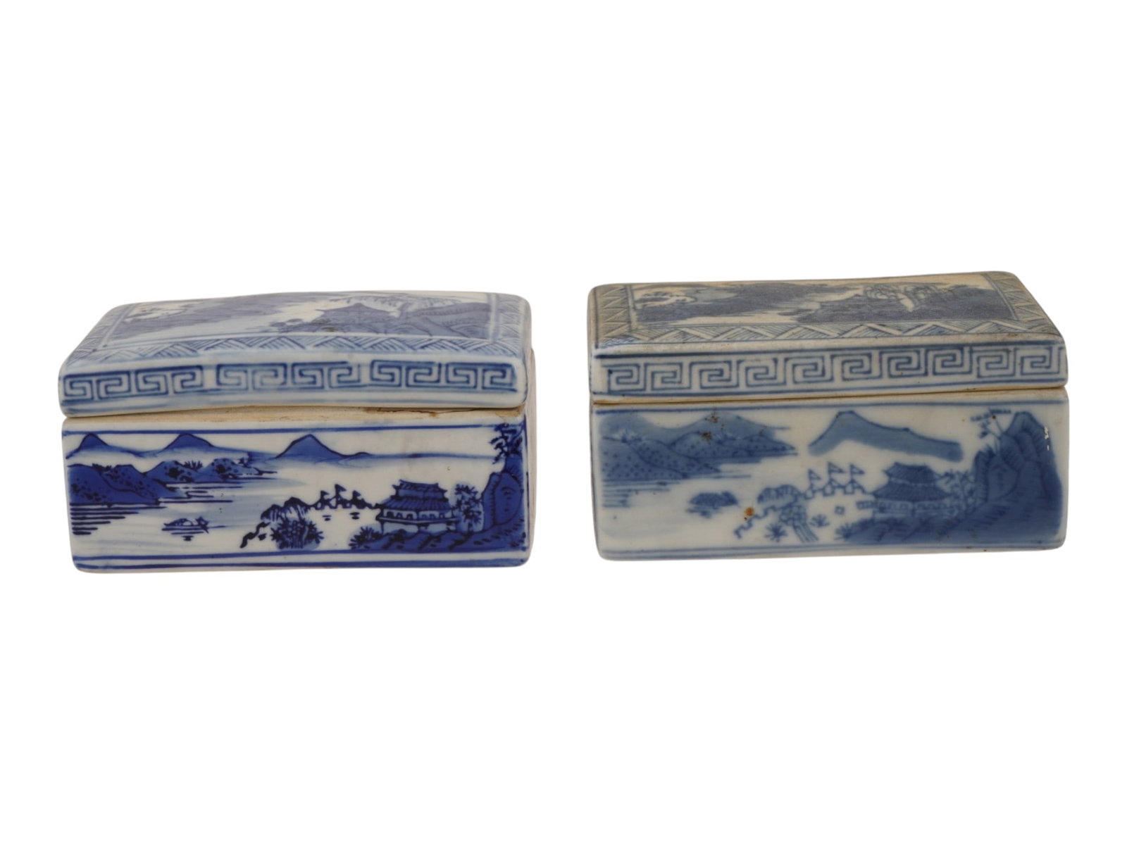 ANTIQUE CHINESE BLUE AND WHITE PORCELAIN LIDDED BOXES: A pair of antique Chinese blue and white porcelain lidded boxes, dating to the Qing Dynasty or early Republic period. Each rectangular box is hand-painted with traditional shanshui landscapes featurin