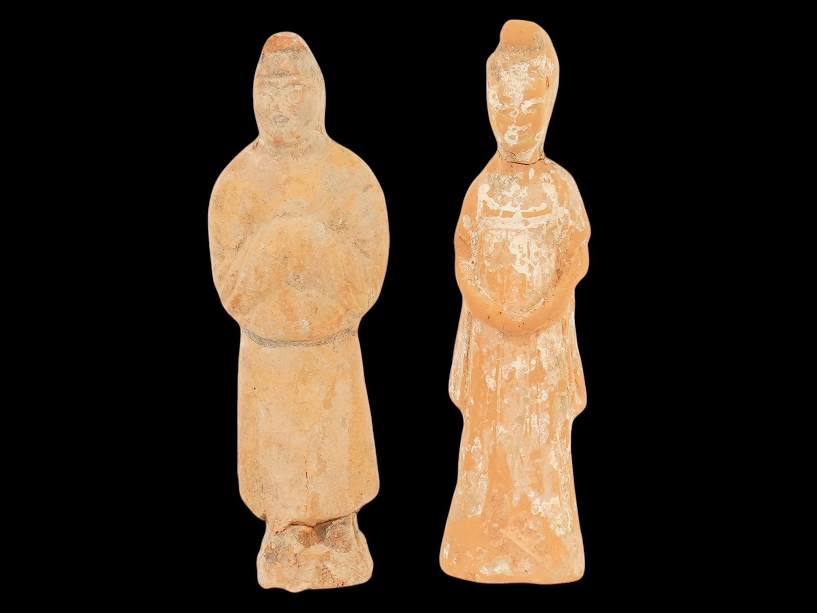 TWO ANCIENT CHINESE HAN DYNASTY TERRACOTTA FIGURINES: A group of two ancient Chinese Han Dynasty terracotta figurines, depicting a male and female figure and dating to approximately 100 to 300 AD. Modeled in clay with stylized features and simple drapery