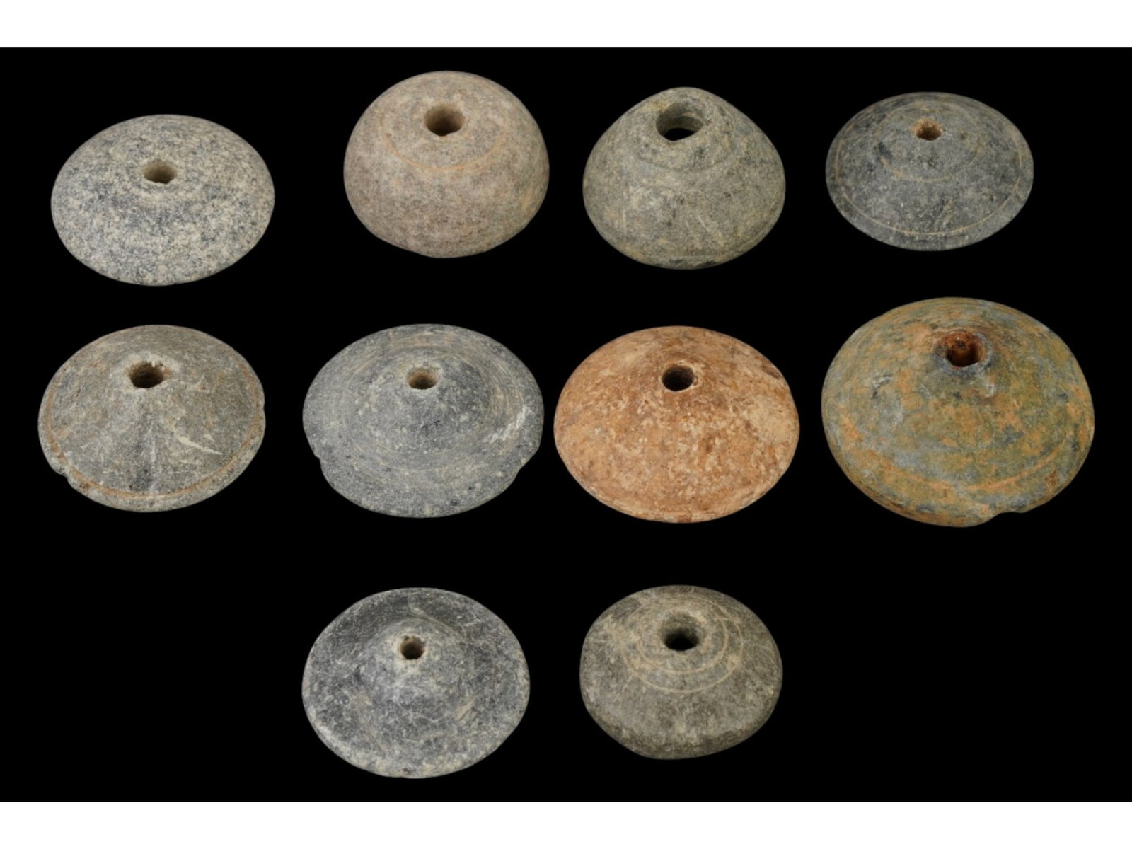 LOT ANCIENT HOLY LAND SPINDLE WHORLS 500 BC TO 200 AD: A group of ten ancient Holy Land carved steatite spindle whorls. Circa 500 BC to 200 AD. All the items are various in size, nearly the same in shape, round with a hole in the middle and decorated with