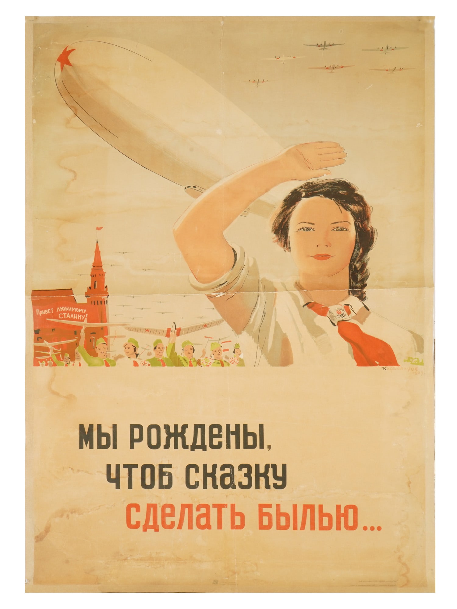 1937 RUSSIAN SOVIET ERA PROPAGANDA POSTER KARACHENTSOV: A Russian Soviet era propaganda poster. The print depicts a pioneer parade on Red Square and an airship in the sky. Titled below: We were born to make a fairy tale come true. Design by Pyotr Karachent