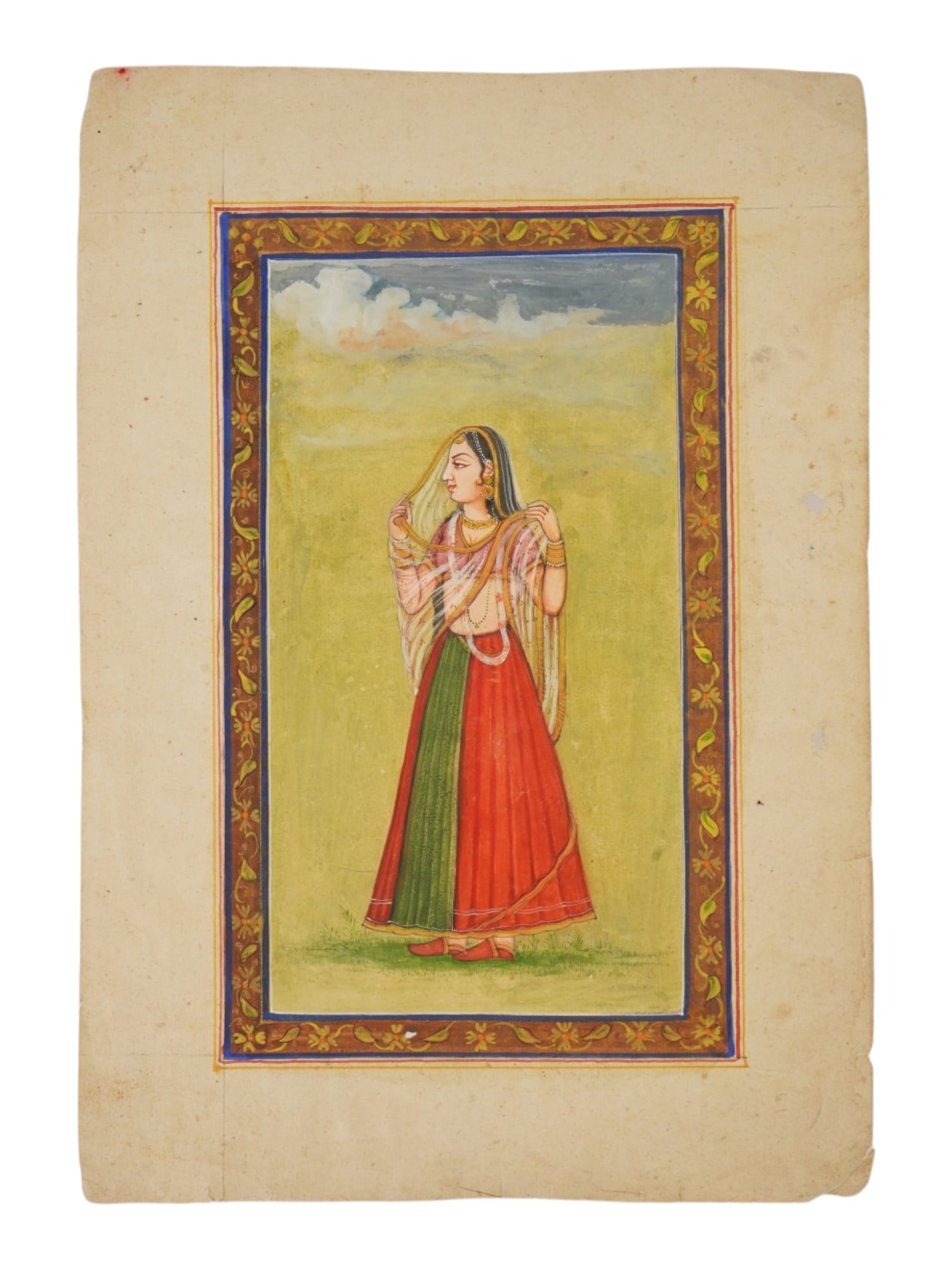 INDIAN MUGHAL ART MINIATURE PAINTING OF ROYAL WOMAN: An Indian mixed media miniature painting depicting a portrait of a standing royal lady in profile against a simplified landscape. The figure is dressed in a traditional bicolored ghagra and a transluc