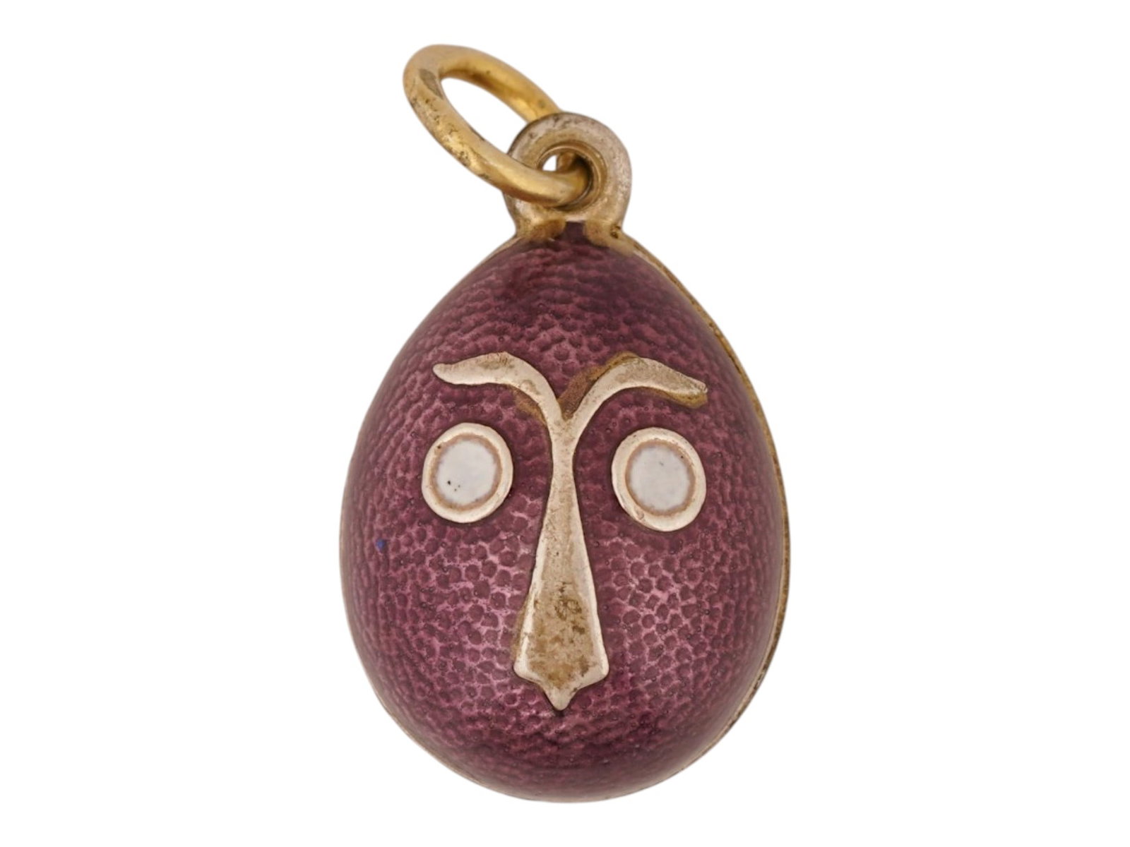RUSSIAN SILVER GUILLOCHE ENAMEL EASTER EGG PENDANT: A Russian gilt silver Easter Egg pendant. Purple guilloche enamel surface with face motif on each side, the eyes are white enameled. Hallmark of 84 silver standard and makers mark are on the fitting r