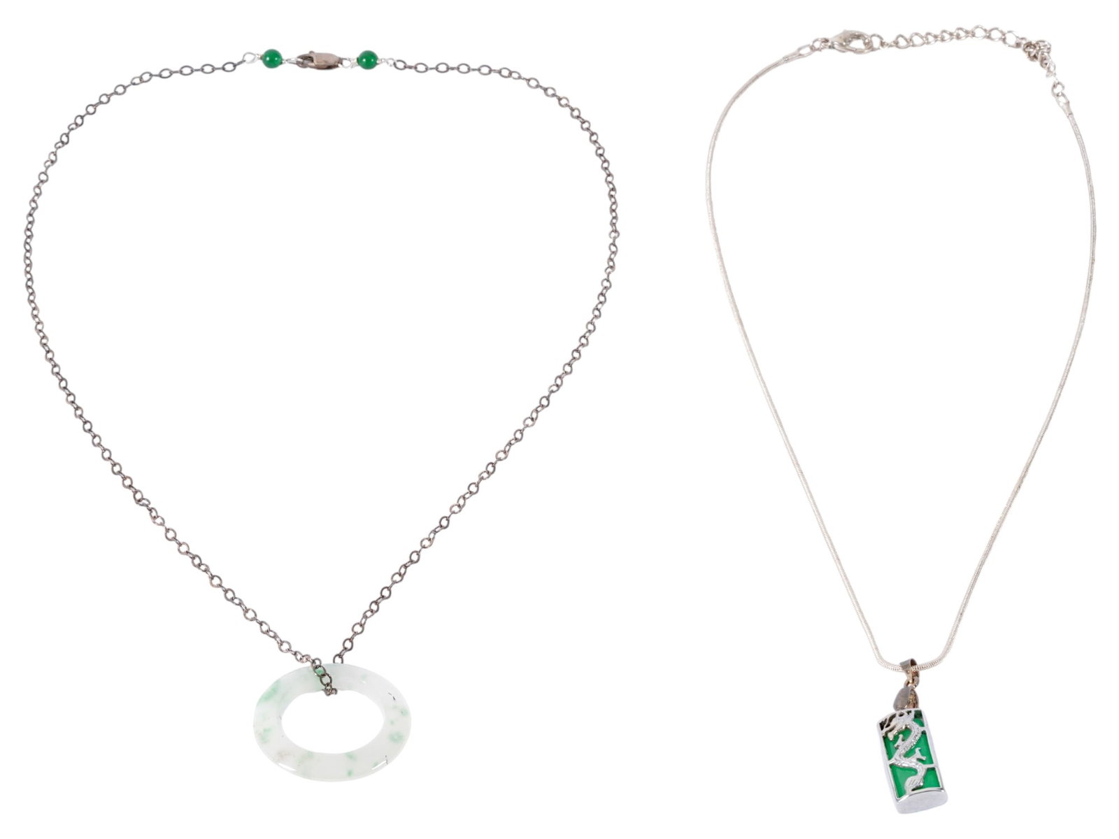 SILVER JADE PENDANT NECKLACES WITH ASIAN MOTIFS: A group of two silver jade pendant necklaces featuring traditional Asian-inspired motifs associated with luck and prosperity. The first necklace showcases a green jade open circle pi disc pendant
