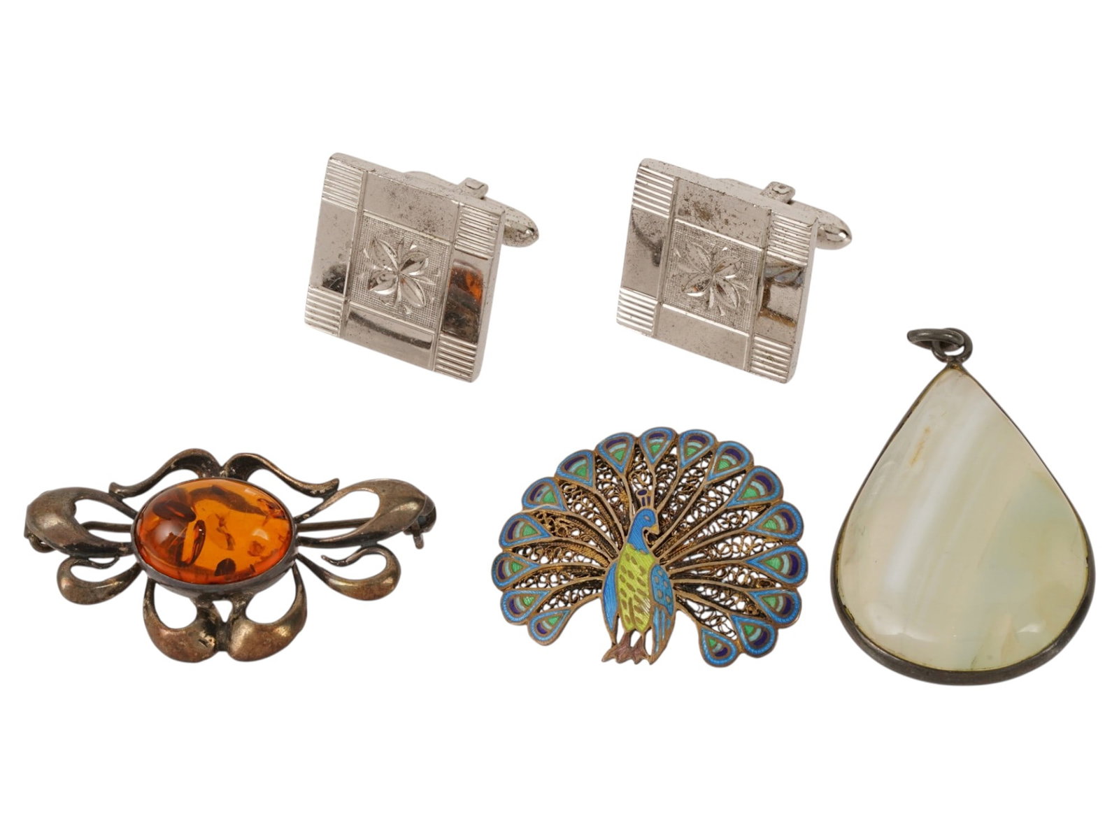 LOT OF COSTUME JEWELRY PENDANT CUFFLINKS AND BROOCHES: A collection of four costume jewelry wares. The collection includes a pair of rectangular silver toned cufflinks featuring engine turned geometric detailing, an oval honey stone brooch set within an