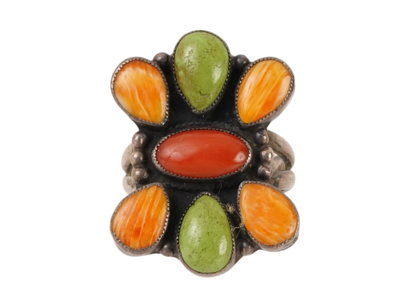 VINTAGE AMERICAN STERLING SILVER CLUSTER RING: A vintage American sterling silver cluster ring featuring a bold floral-inspired design. The centerpiece is an oval red coral cabochon surrounded by vibrant gaspeite and spiny oyster shell accents,