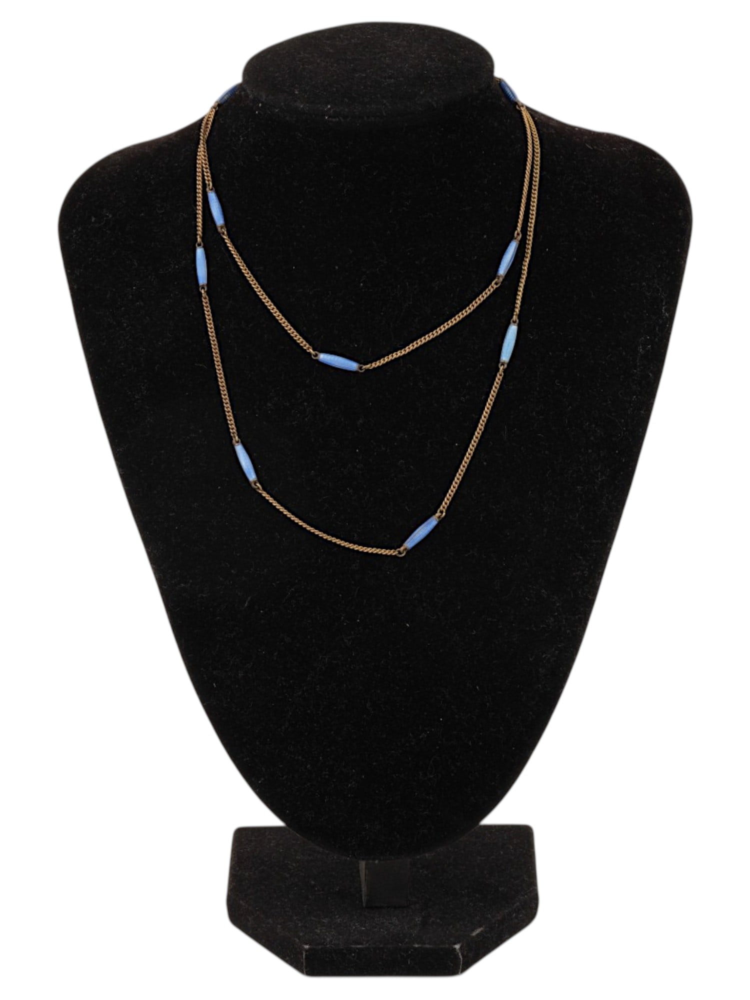 LONG VINTAGE CHAIN NECKLACE W BLUE ELEMENTS MARKED: A long vintage chain necklace in the style of station necklaces or elongated sautoirs from the Art Deco era. A thin metal chain in a gold tone curb or anchor weave, divided at equal intervals by