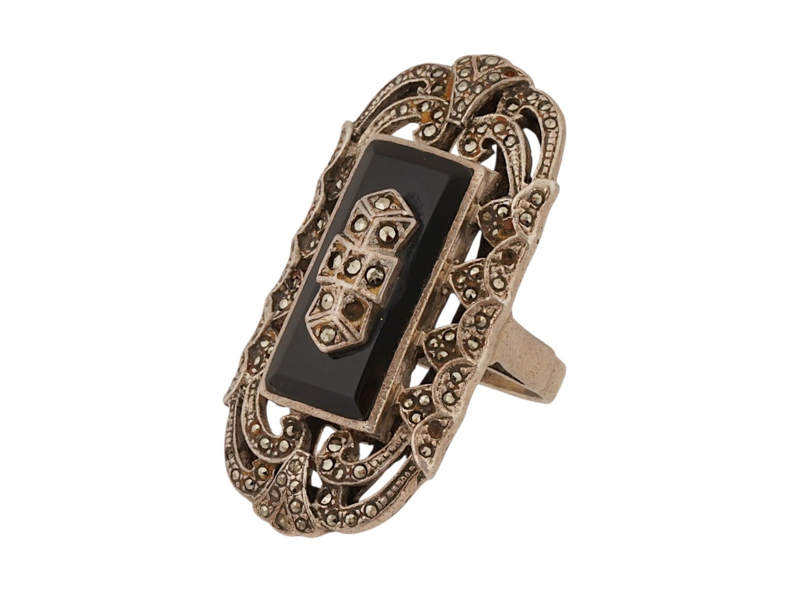 VINTAGE SILVER COCKTAIL RING W BLACK ONYX CENTERPIECE: A vintage sterling silver cocktail ring featuring an elongated rectangular black onyx centerpiece. The ornate geometric setting is embellished with sparkling marcasite accents and intricate openwork
