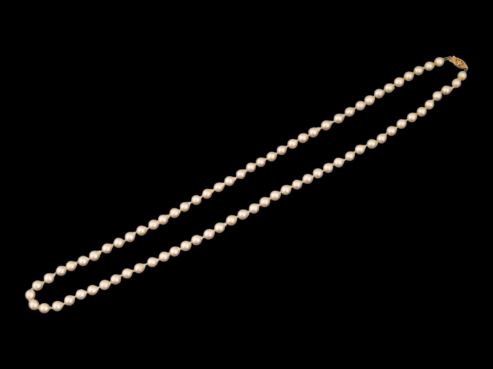 NATURAL SEA PEARL NECKLACE WITH 14K GOLD CLASP: A vintage natural sea pearl necklace with a 14K yellow gold clasp, marked. Total Weight: 37.4 grams. Vintage Elegant Jewelry And Accessories. THIS LOT IS ELIGIBLE FOR A 30-DAY UNCONDITIONAL RETURN FRO