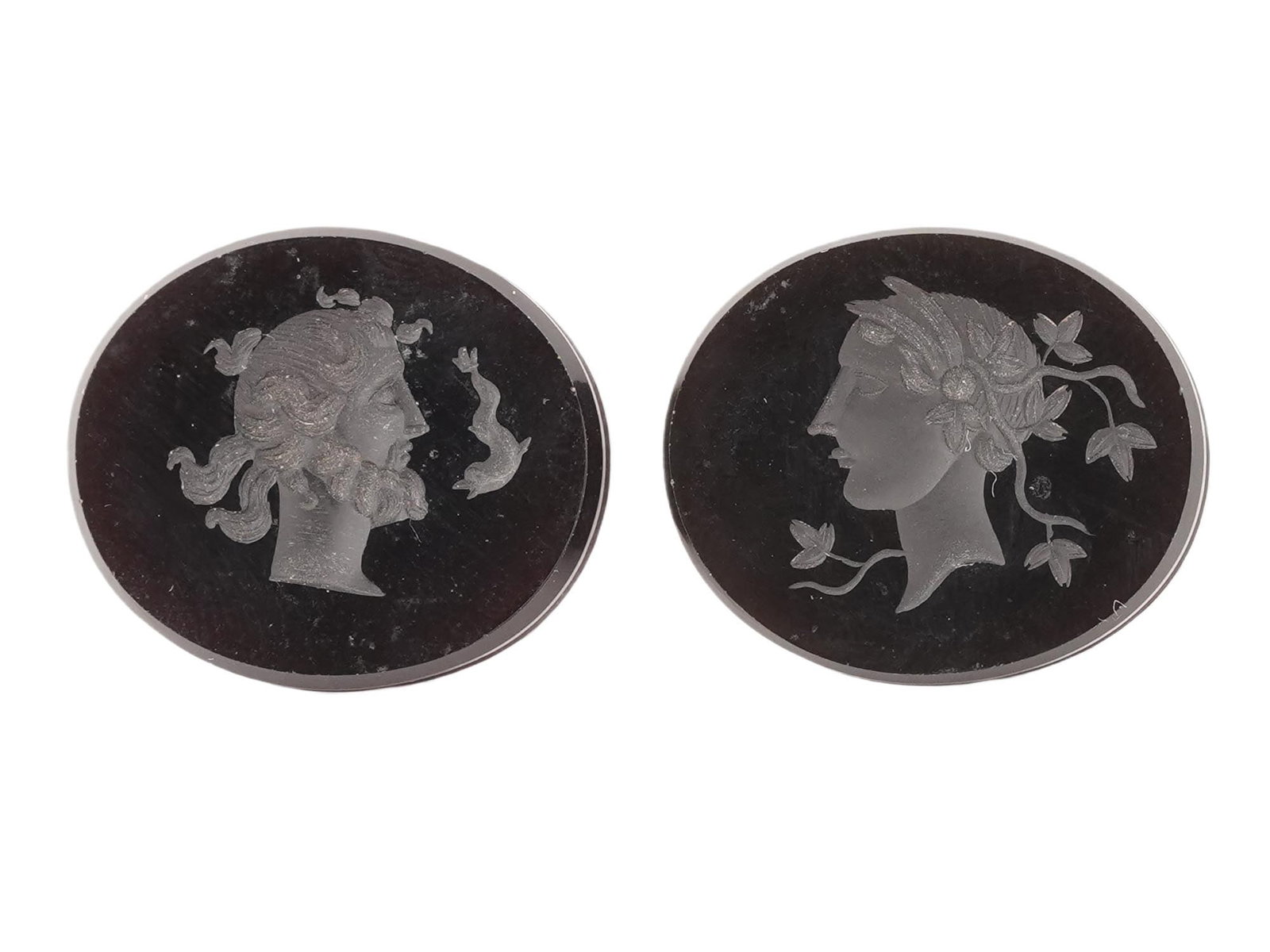 LOT OF TWO ANTIQUE HAND CARVED CAMEO INTAGLIOS: A lot of two antique hand carved cameo intaglios. Each intaglio is oval-shaped and features a finely carved depiction of profile. One features a male profile and the other one a female. The carving is