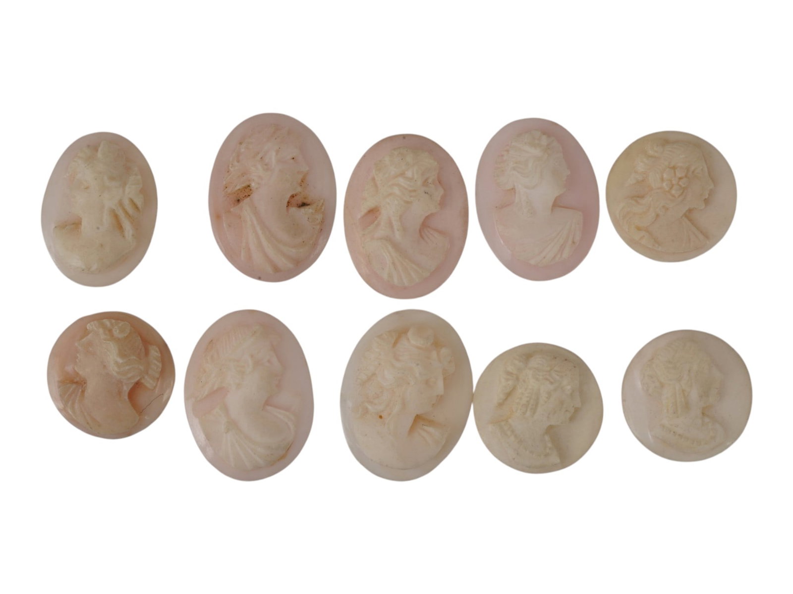COLLECTION OF VINTAGE HAND CARVED CONCH SHELL CAMEOS: A collection of 10 vintage hand-carved conch shell cameos with female portrait profiles. Several figures wear grape leaves in their hair, evoking the Bacchante motif of 19th-century carving. Vintage C