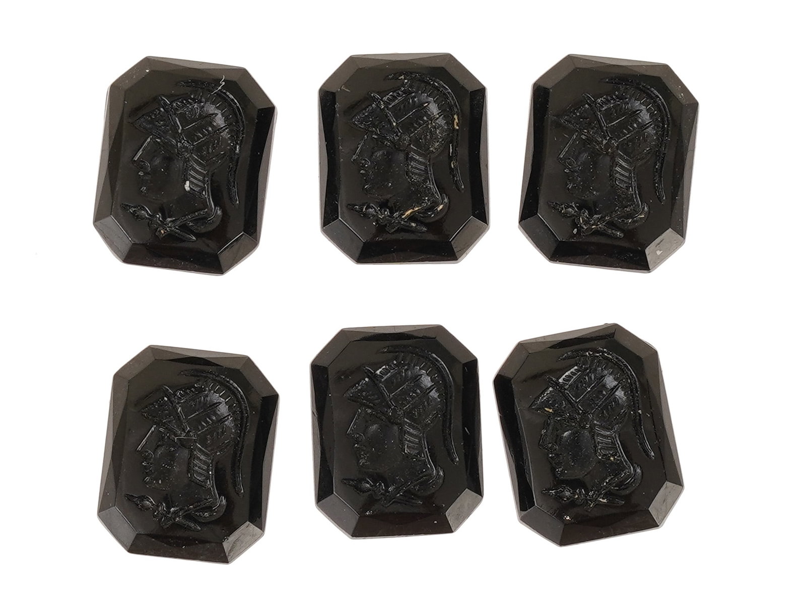 COLLECTION OF WARRIOR PROFILE PORTRAIT GLASS CAMEOS: A collection of black glass cameos. A total of 6 items. Each piece depicts a warrior left profile portrait rendered in high relief. Octagonal shape. Collectible Jewelry And Glyptic Art, Sculpture. THI