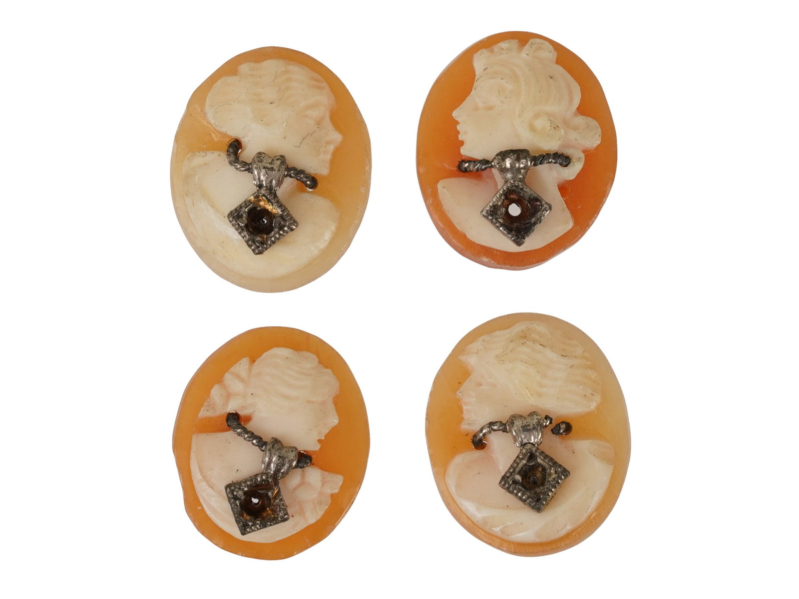 CARVED SHELL FEMALE PORTRAIT CAMEOS W METAL: A lot of hand carved shell cameos. A total of 4 items. Each piece depicts a female profile portrait rendered in high relief. Oval shape. Decorated with miniature metal necklaces, ready for stone inser