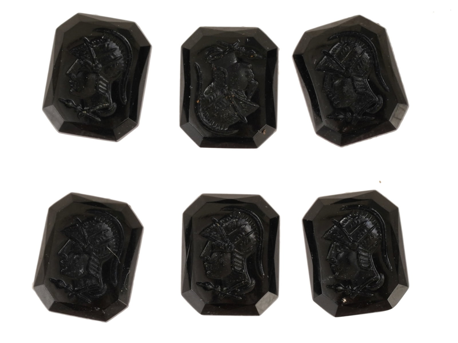 COLLECTION OF WARRIOR PROFILE PORTRAIT GLASS CAMEOS: A collection of black glass cameos. A total of 6 items. Each piece depicts a warrior left profile portrait rendered in high relief. Octagonal shape. Collectible Jewelry And Glyptic Art, Sculpture. THI