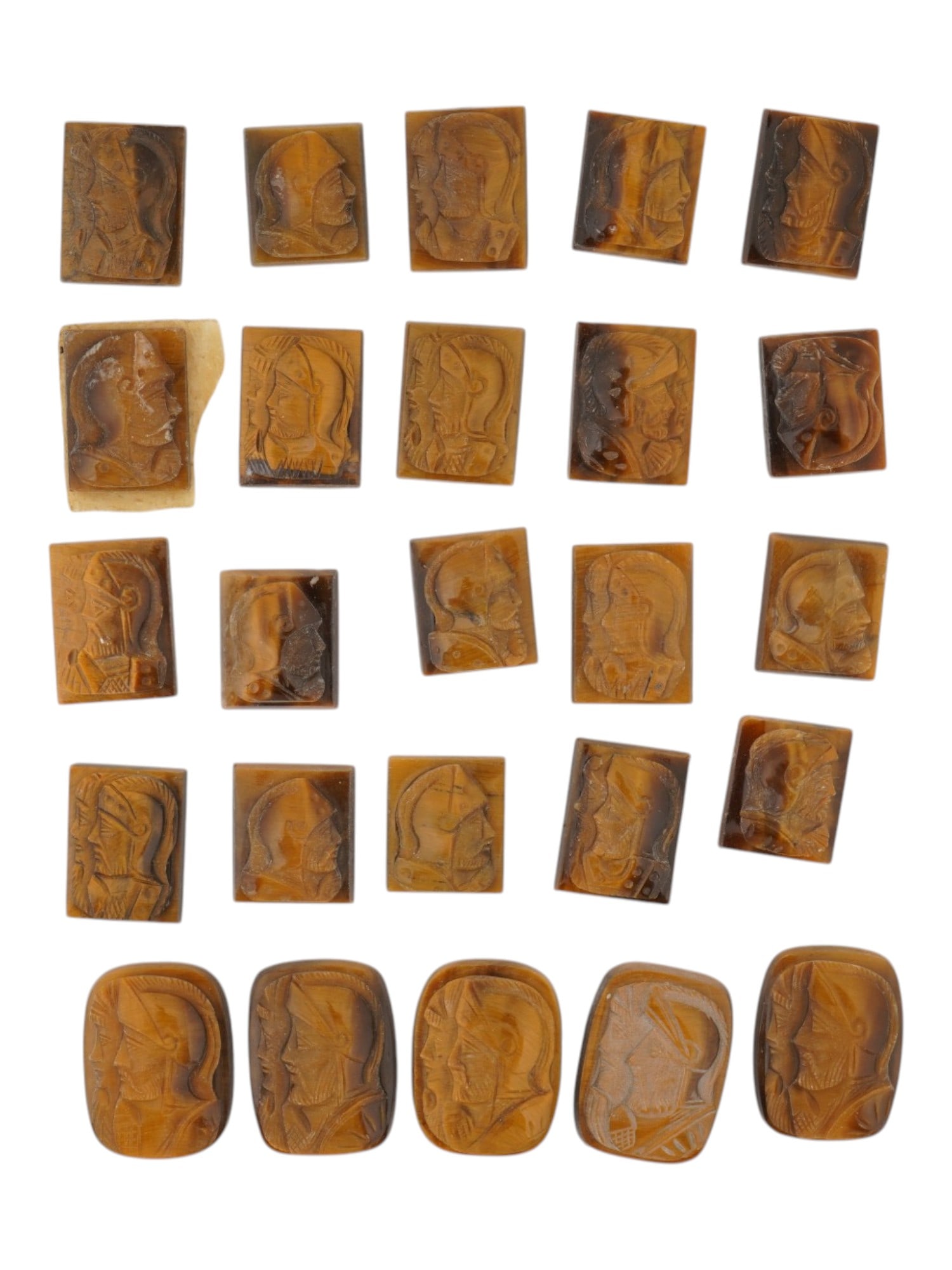 COLLECTION OF PORTRAIT CARVED TIGERS EYE CAMEOS: A collection of hand carved tigers eye cameos. A total of 25 items. Each piece features a knight profile portrait rendered in high relief. Rectangular shape. Collectible Jewelry And Glyptic Art, Sculp