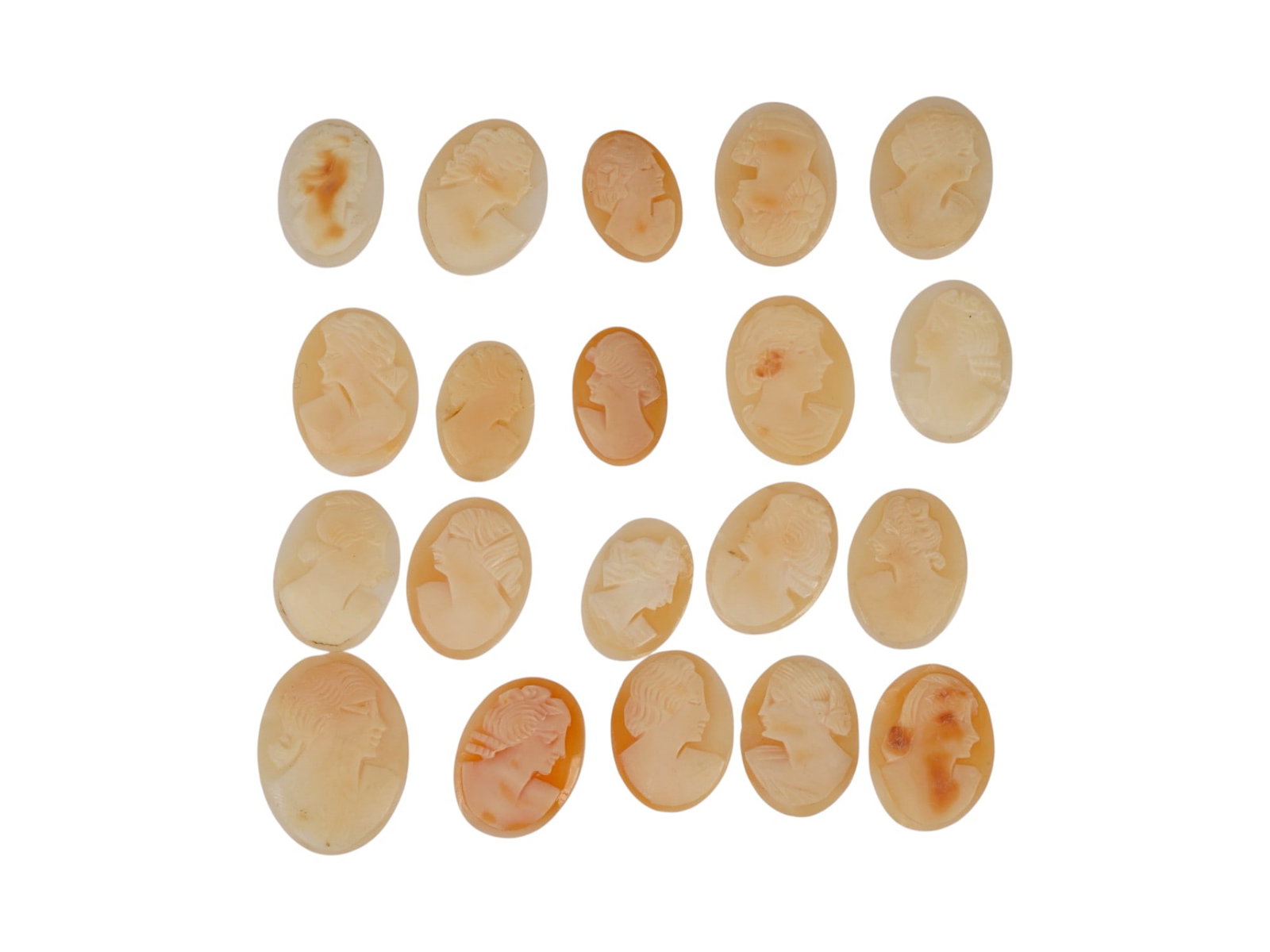 COLLECTION OF 20 VINTAGE FEMALE PROFILE SHELL CAMEOS: A collection of 20 vintage loose shell cameos, each hand-carved with a classical female profile. Fashioned from natural marine shell. The unmounted oval plaques showcase contrasting relief work, varie