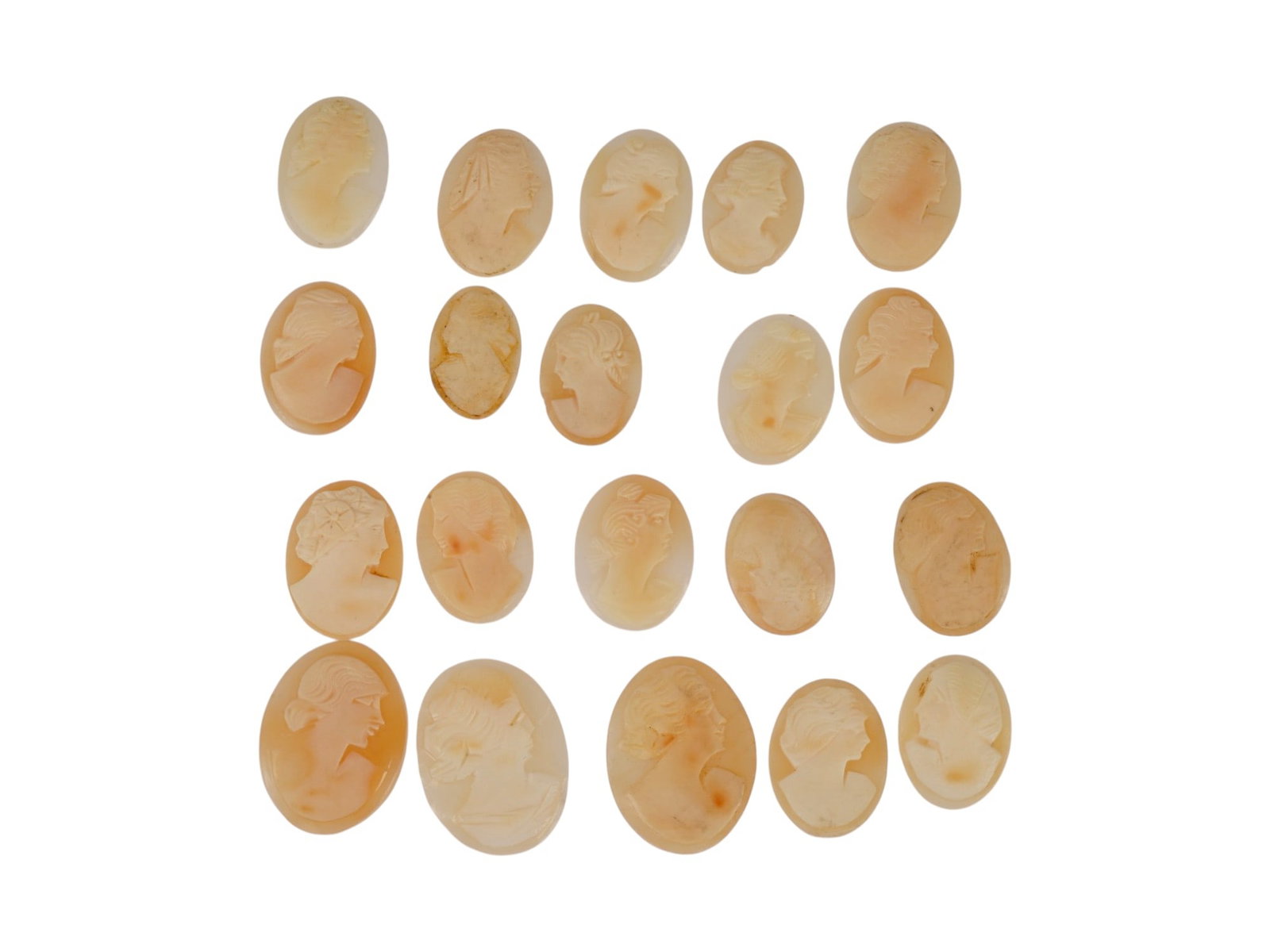 COLLECTION OF 20 VINTAGE FEMALE PROFILE SHELL CAMEOS: A collection of 20 vintage loose shell cameos, each hand-carved with a classical female profile. Fashioned from natural marine shell. The unmounted oval plaques showcase contrasting relief work, varie