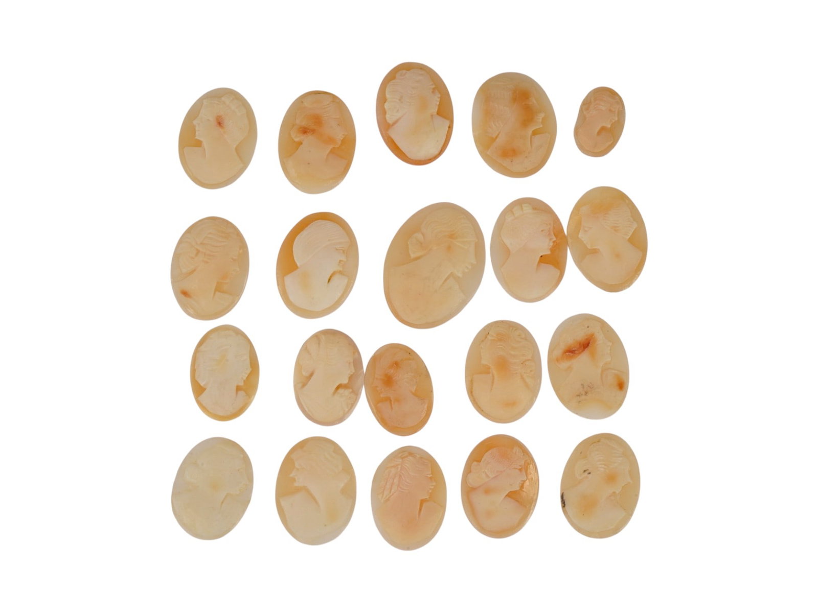 COLLECTION OF 20 VINTAGE FEMALE PROFILE SHELL CAMEOS: A collection of 20 vintage loose shell cameos, each hand-carved with a classical female profile. Fashioned from natural marine shell. The unmounted oval plaques showcase contrasting relief work, varie
