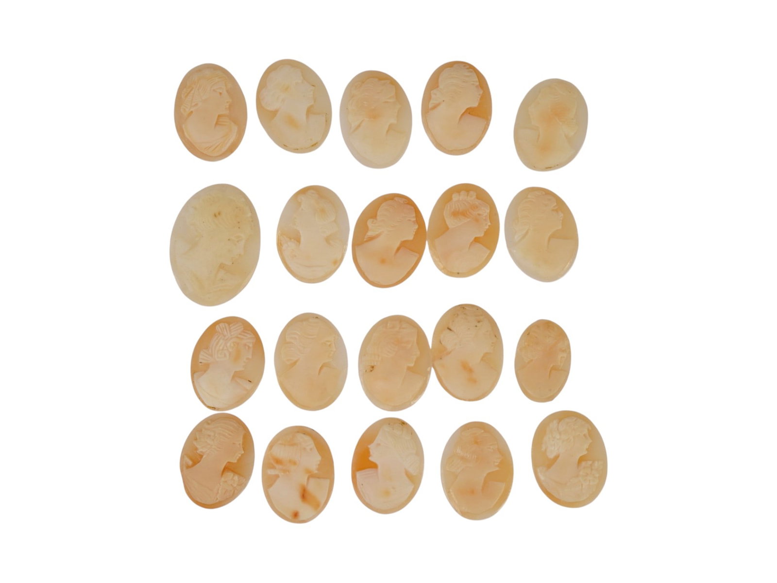 LOT OF FEMALE PORTRAIT CARVED SHELL CAMEOS: A lot of 20 hand carved conch shell cameos. Each piece depicts a female profile portrait rendered in high relief. Oval shape. Collectible Jewelry And Glyptic Art, Sculpture. THIS LOT IS ELIGIBLE FOR A
