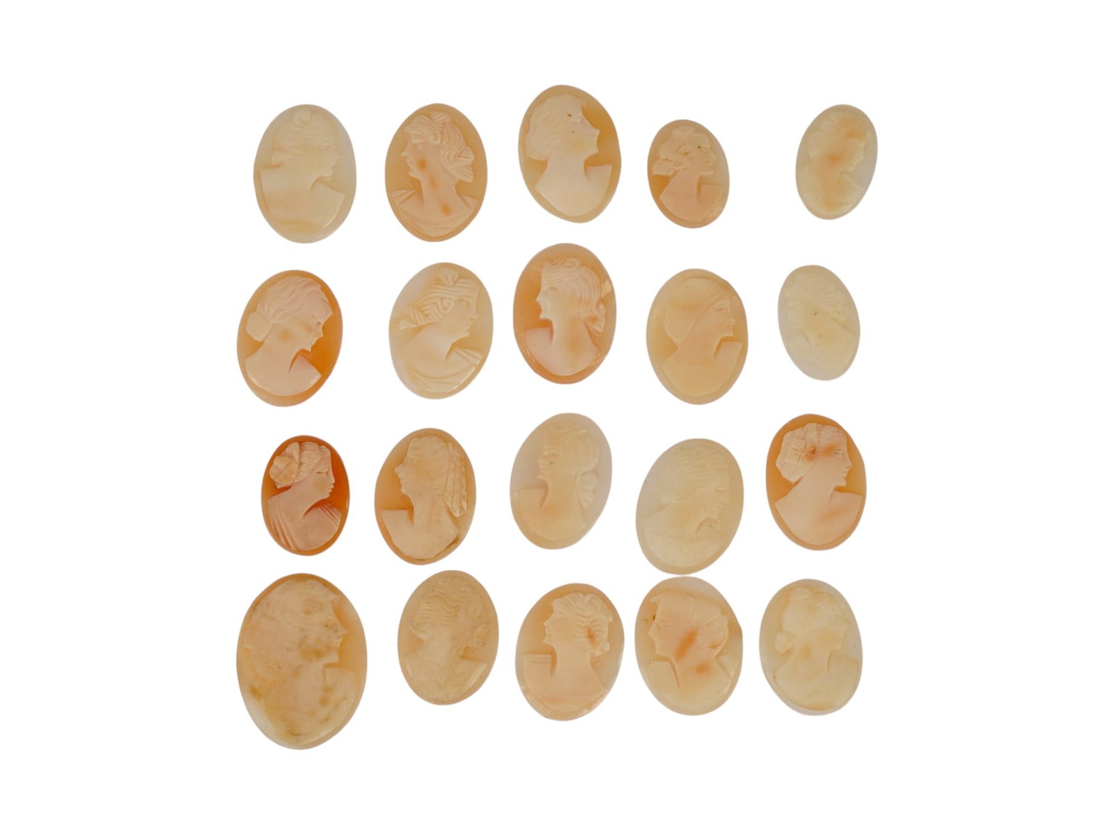 LOT OF FEMALE PORTRAIT CARVED SHELL CAMEOS: A lot of 20 hand carved conch shell cameos. Each piece depicts a female profile portrait rendered in high relief. Oval shape. Collectible Jewelry And Glyptic Art, Sculpture. THIS LOT IS ELIGIBLE FOR A