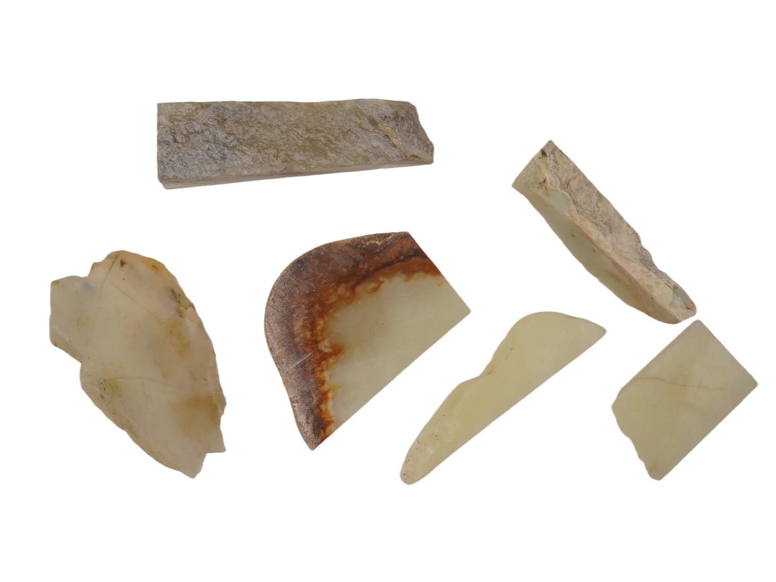SIX WHITE JADE STONE PIECES IN CELADON COLOR: A group of six white jade stone pieces in celadon color. The stones are of varying shapes with a partially polished surface. Collectible Gemstone Carvings. Weight 427g. THIS LOT IS ELIGIBLE FOR A 30-D