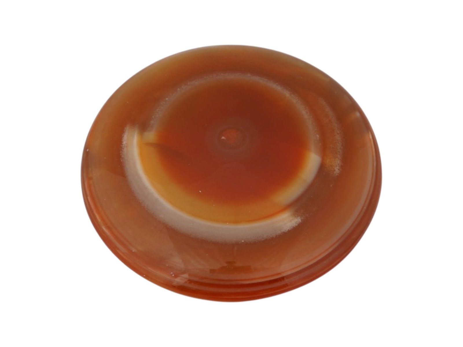 LARGE CIRCULAR CABOCHON FORM BANDED AGATE SPECIMEN: A large banded agate specimen carved into a circular cabochon form, featuring concentric zones of carnelian red, ochre, and cream. The stone is cut as a low cabochon with a polished surface and a flat