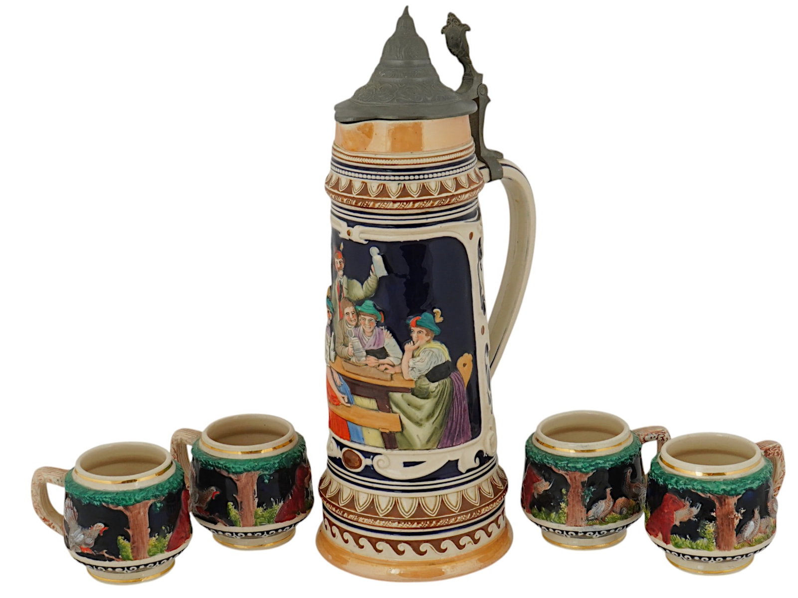 GERMAN SET OF LARGE BEER STEIN MUG AND FOUR CUPS: A Mid 20th century German beer set of a large beer stein mug with a hinged tin lid and four cups. The exteriors of the wares are decorated with relief and hand painted tavern and hunting scenes. Marke