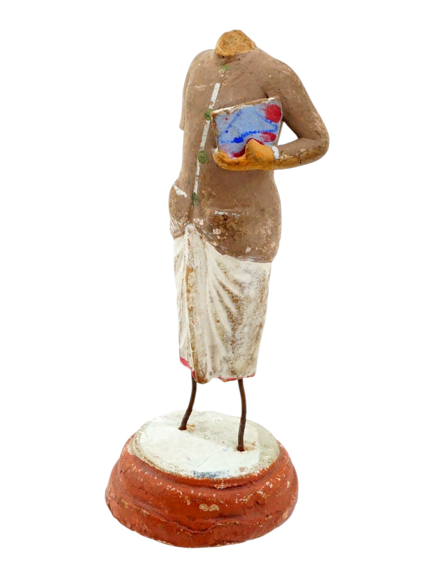 17TH CENTURY HAND PAINTED CLAY TOY FIGURINE W BASE: A 17th century hand painted clay figurine depicting a standing figure dressed in a textured brown tunic and a draped white lower garment reminiscent of a traditional dhoti. The figure is captured in