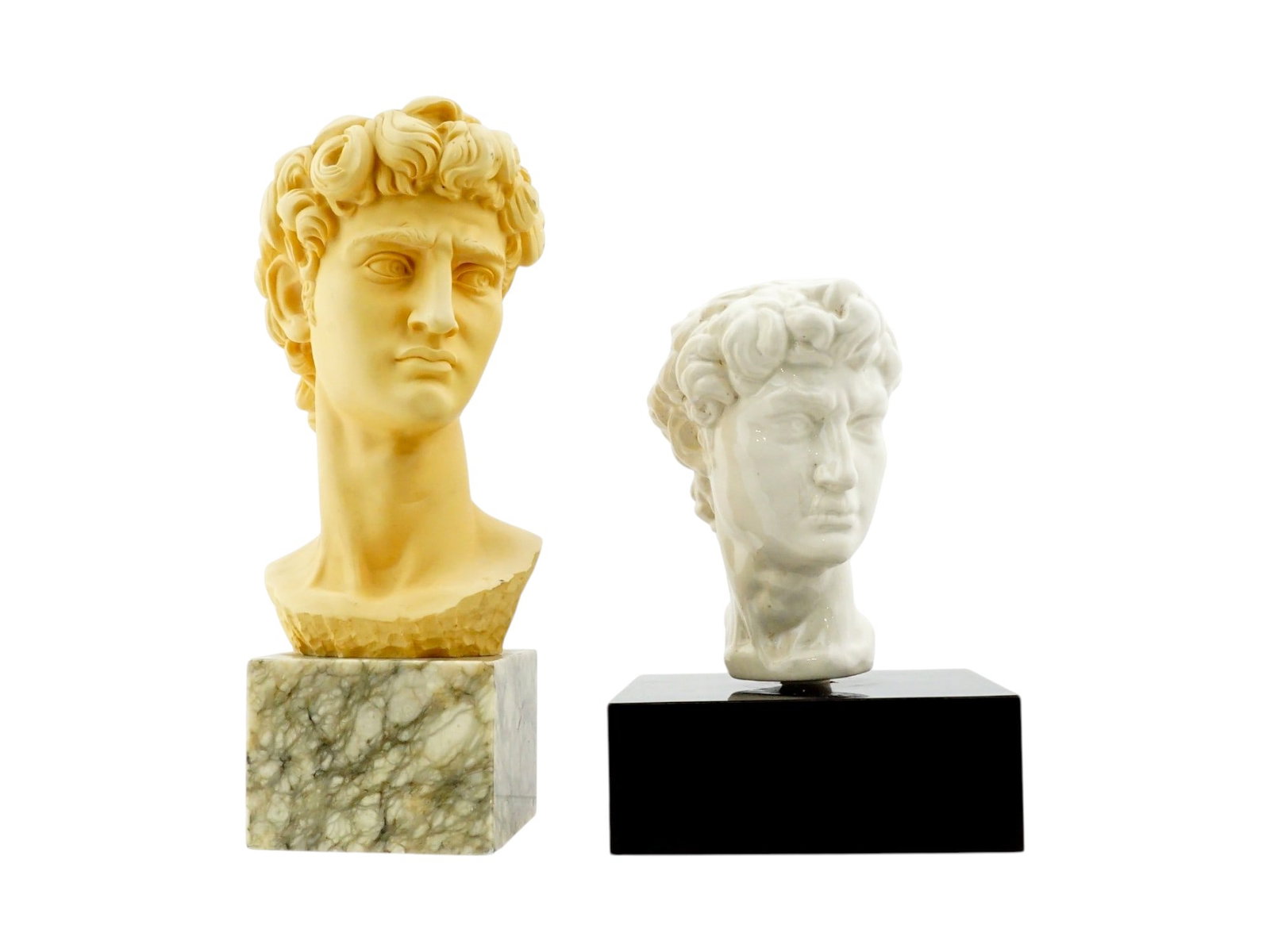 REPLICAS OF MICHELANGELO BUONARROTIS BUST OF DAVID: A lot of two replicas of Michelangelo Buonarrotis bust of David, made of porcelain and composite material with marble chips. The first item was created by Arnaldo Gianelli, 1907 to 2005, an Italian
