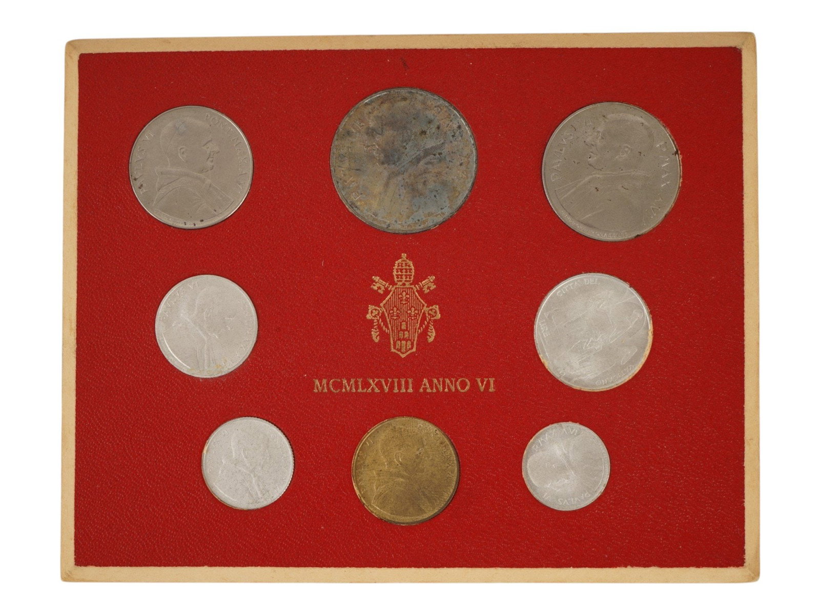 VATICAN ANNUAL COIN SET FROM 1968 MCMLXVIII ANNO VI: An Official Vatican annual coin set from 1968 MCMLXVIII ANNO VI, from the pontificate of Pope Paul VI. Number of coins: 8. The largest coin at the top center is the silver 500 lira piece. The coins ar