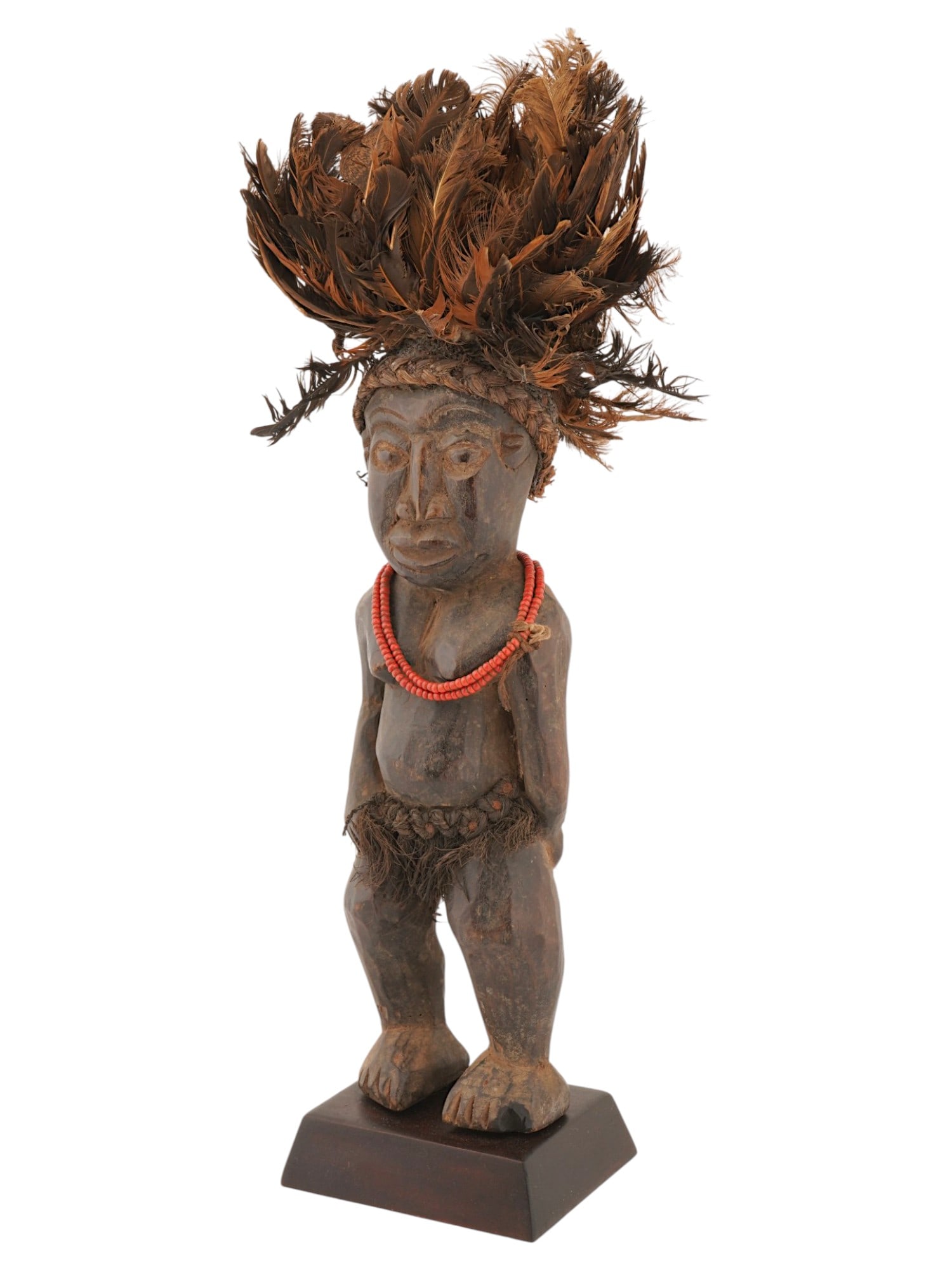 AFRICAN BAMILEKE CARVED WOODEN FIGURINE W FEATHERS: An African hand carved wooden figurine originates from the Bamileke people of the Cameroon Grassfields region. The ware depicts a standing male figure. The sculpture is adorned with an expansive