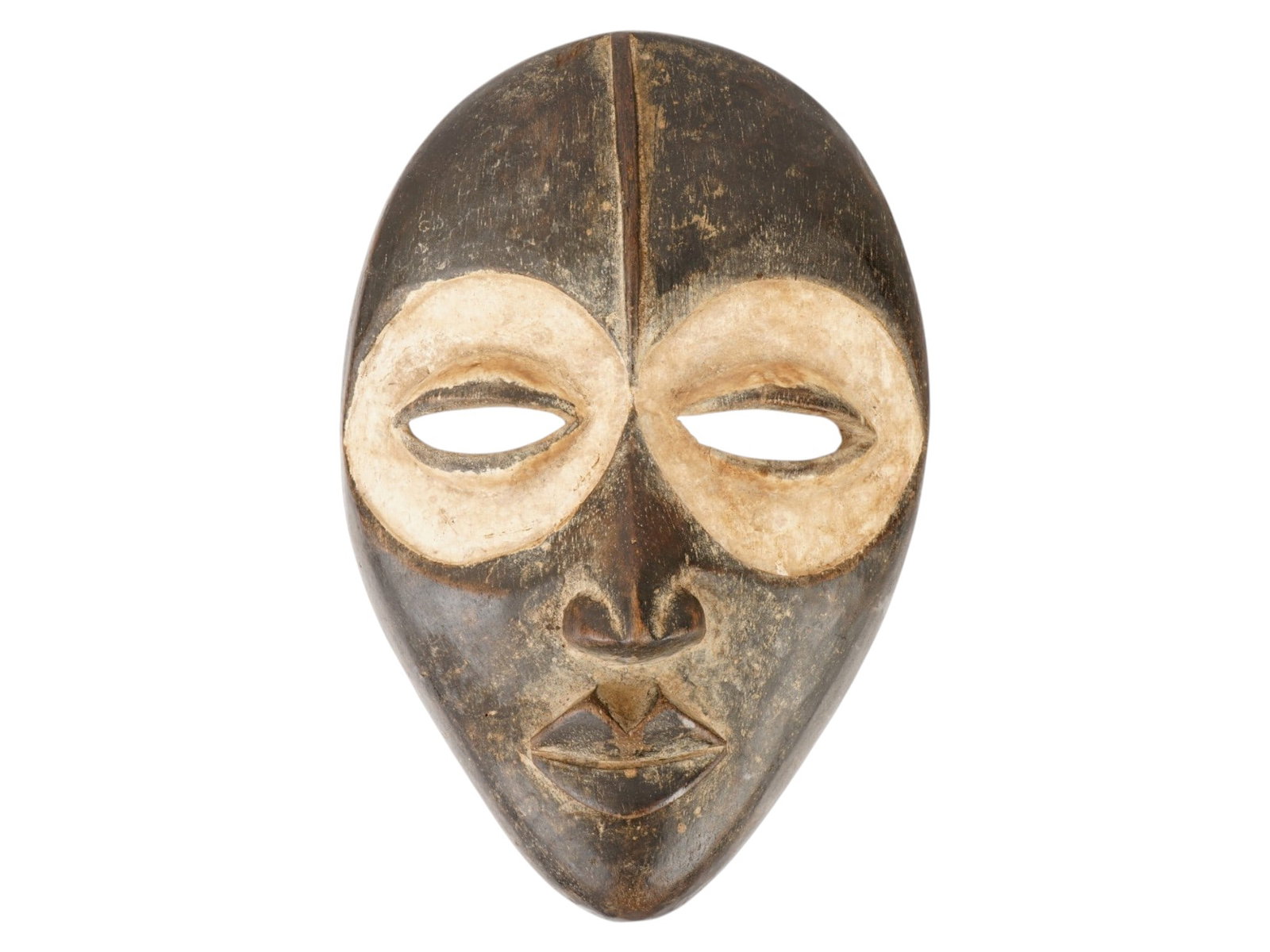 AFRICAN DAN CARVED WOOD TRIBAL MASK FROM LIBERIA: An African hand carved wood tribal mask of the Dan people from Liberia. They are officially known as Yacouba in Ivory Coast. The oval face is depicted with a high forehead, expanding nose, a protrudin