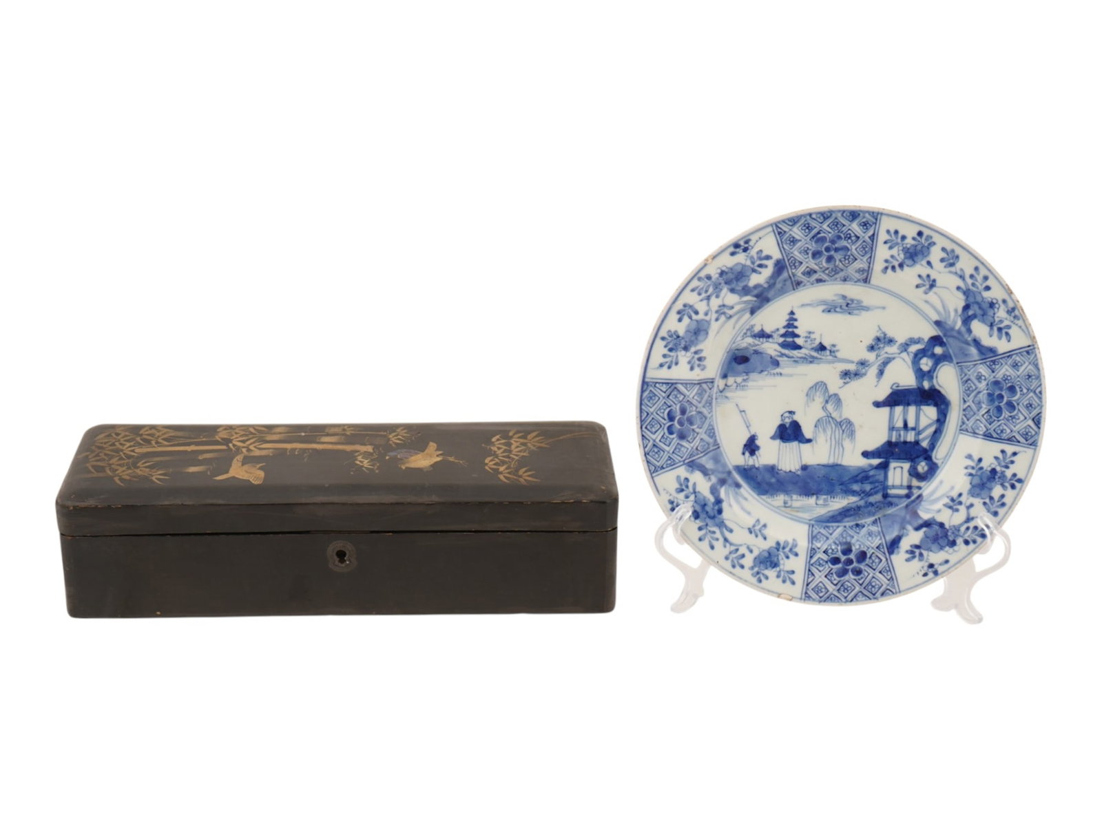 ANTIQUE CHINESE PORCELAIN PLATE AND LACQUERED WOOD BOX: An antique Chinese Export blue and white porcelain plate and a black lacquered wood box. The porcelain plate is decorated with a figural garden scene within a paneled floral border, while the rectangu