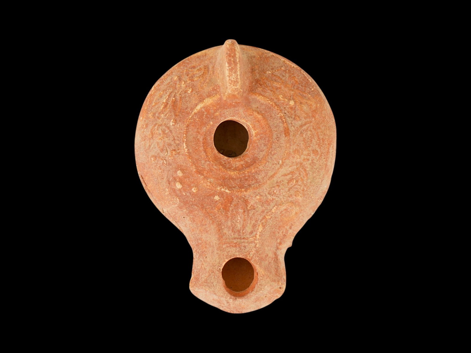 ANCIENT ROMAN TERRACOTTA OIL LAMP W OLIVE WREATH DESIGN: An ancient Roman terracotta pottery oil lamp. The body of the lamp is adorned with an embossed olive wreath design on the shoulders. The lamp features a raised circle nozzle top and a raised handle. C